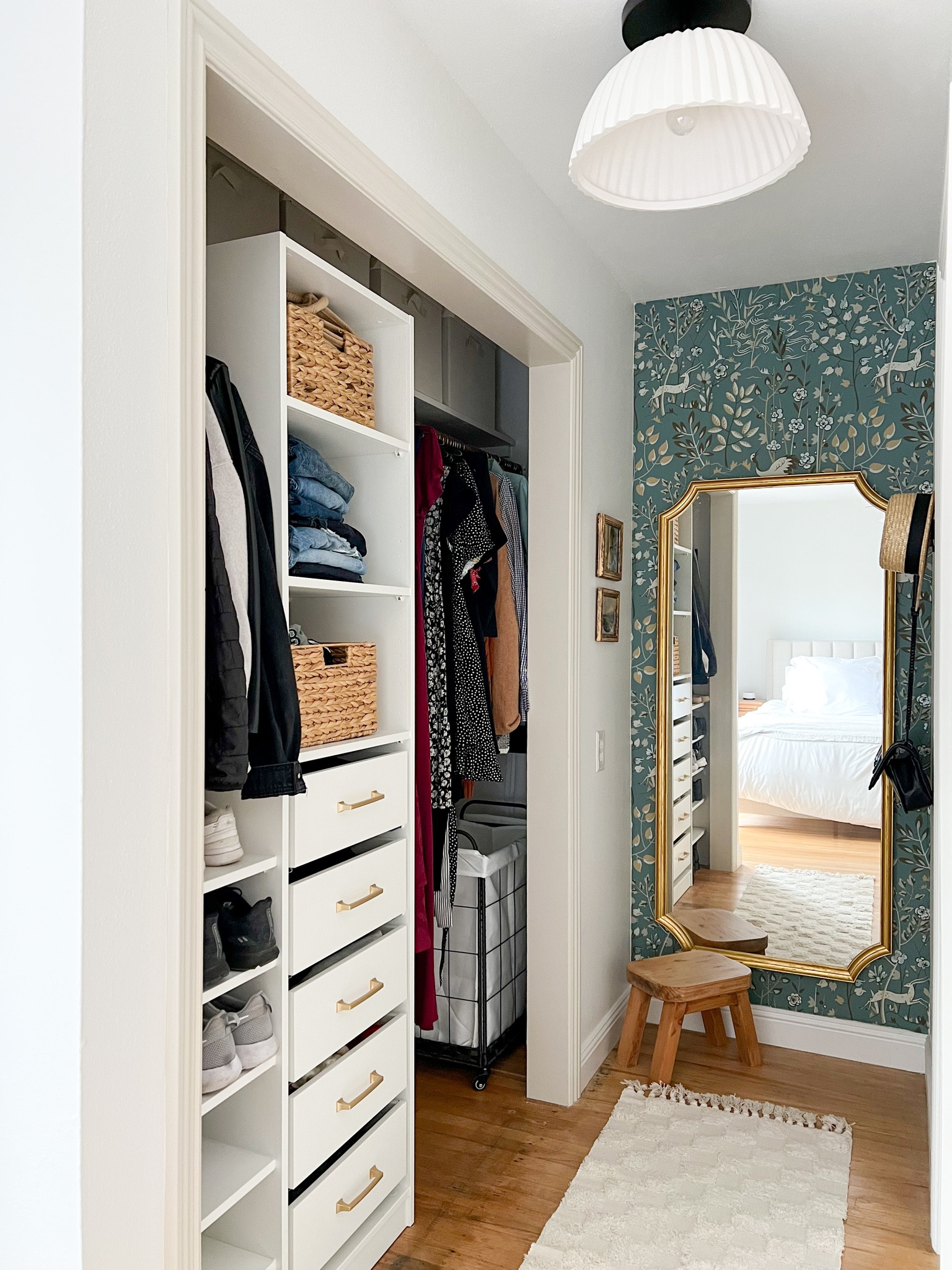Closet - blue green wallpaper, scalloped semi flush mount light fixture, storage baskets, closet storage, neutral runner, gold handles, laundry basket

Mirror is Ikea!