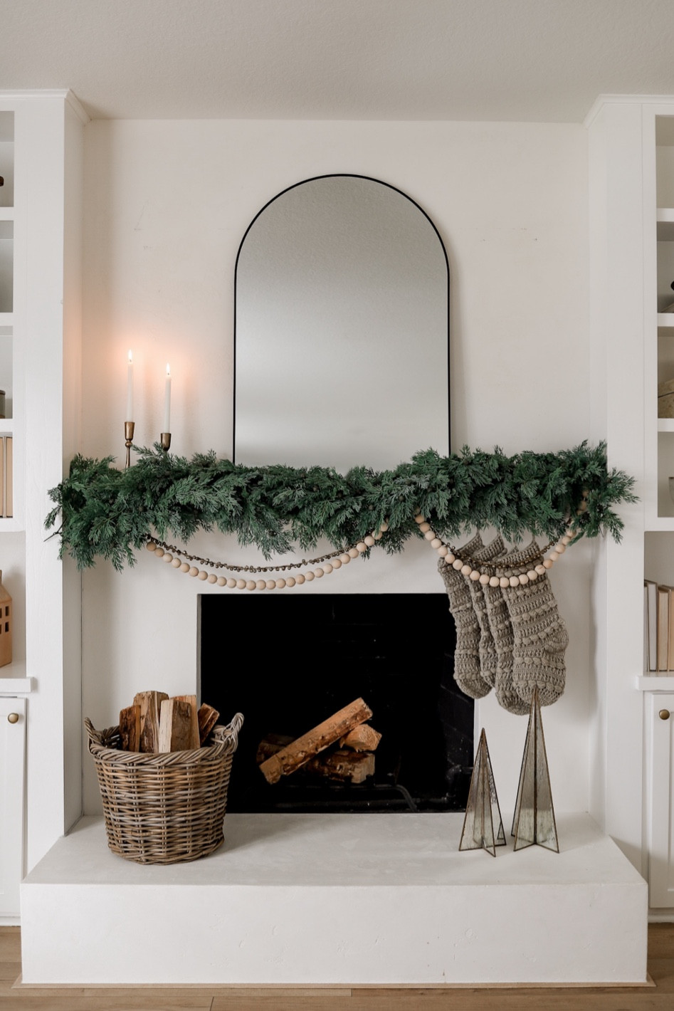This year’s holiday mantel styling!☺️

What do you guys think?? Hope you love it and can use it as inspiration for your home this year! 🥰

STYLING DETAILS 👇🏼

•Layered two garlands to get a fuller look, but one would work great! I love the natural look of the greenery… those berries add the perfect amount of texture! 
•Only needed one bell garland and one wood ball garland here.
• I used command hooks to hang everything! 
• See ‘fireplace’ highlight for details on this brick to plaster fireplace makeover! 

#LTKhome #LTKHoliday #LTKSeasonal