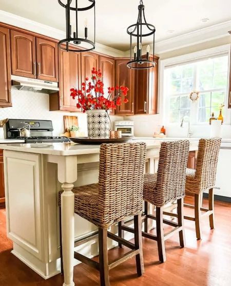Update your kitchen without painting your cherry cabinets! New black pendant lighting, new quartz, countertops, and new rattan, barstool chairs easily give the space a fresh look. #kitchen #diyrenovation #homeimprovement 

#LTKstyletip #LTKhome