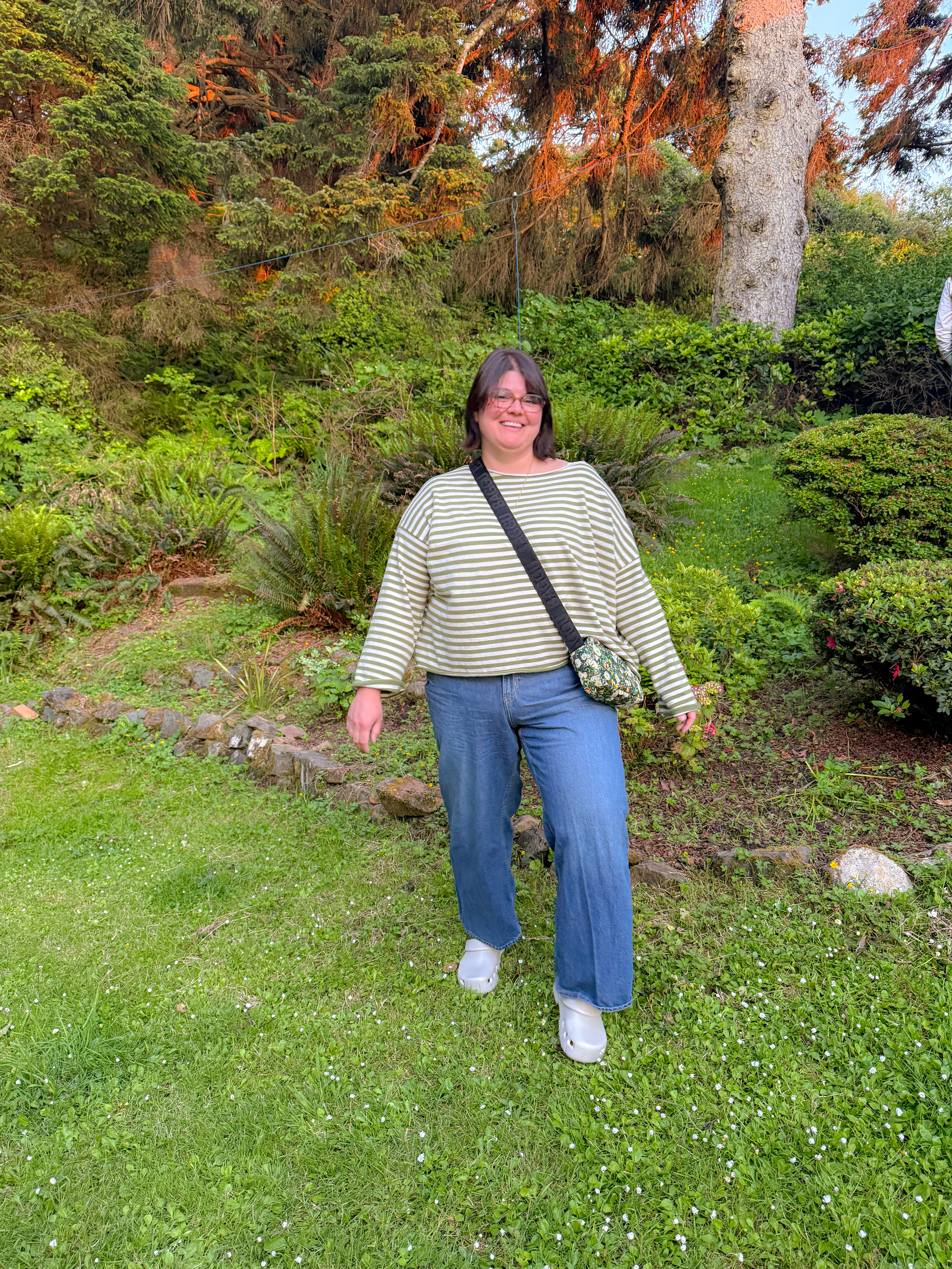 This olive stripe top is the kind of easy I want every travel outfit to be: boxy, breathable, zero effort. Wide-leg jeans and clog sandals make it walkable for a full day, and the floral crossbody adds color without trying too hard. Golden hour in the garden was an unplanned bonus.

Hashtags
#LTKtravel #LTKstyletip #LTKfindsunder50 #stripedtop #widelegjeans #casualstyle #travelstyle #everydayoutfit #pnwstyle #clogsandals 

 