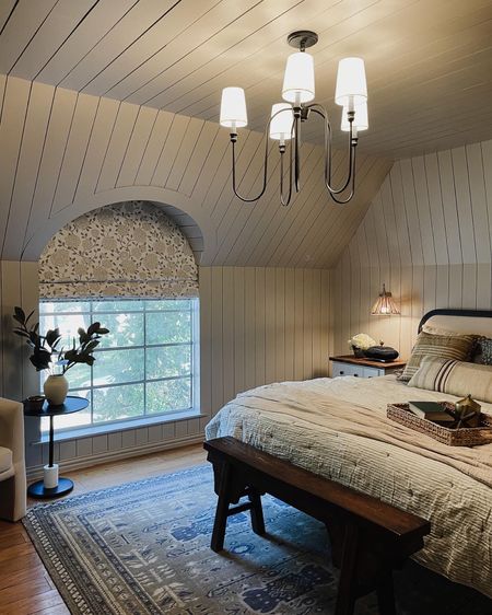 Cottage style bedroom decor, soft curved headboard matte black with a matte black chandelier and rattan and gold swing arm sconces  

#LTKhome #LTKsalealert #LTKFind