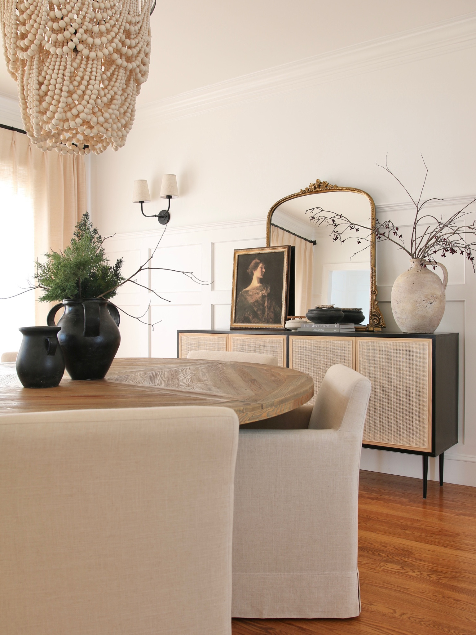 I full view tying the dining area, console table and window treatment. 
In the dining room, I have a round rustic farmhouse table from Amazon and linen upholstered rolling dining armchairs. 
The console table is a DIY inspired by the Pottery Barn Dolores cane console table with the famous Anthro Gleaming Primrose mirror 

#LTKhome #LTKFind #LTKstyletip