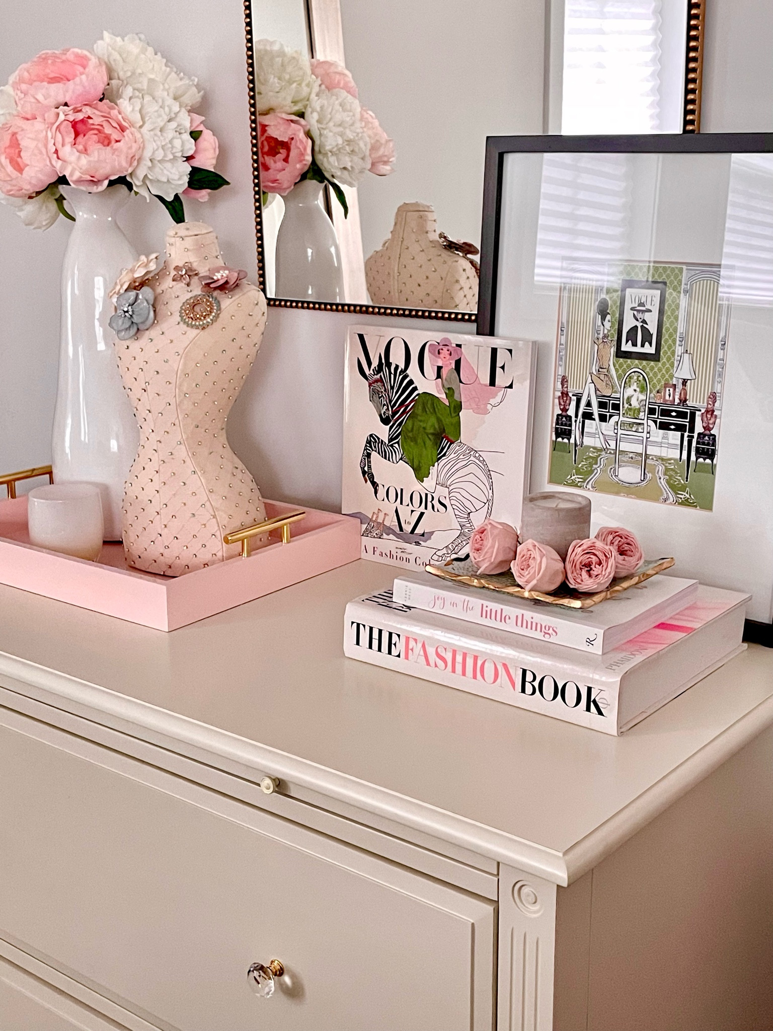 Instantly dress up a night stand, console table, vanity or dresser with some cute books, prints, candles, etc. In this pic, I have everything styled on my file cabinet that looks like a small dresser. I changed the knobs to go better with my decor. Oh, and the pink tray is currently on sale and comes in other colors!

#LTKhome #LTKsalealert #LTKGiftGuide