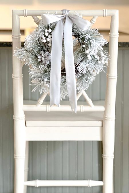 Flocked mini wreath with white berries on a cream colored bamboo counter stool with silver satin ribbon bow. Holiday decor, grandmillennial, coastal, New England style. 

#LTKhome #LTKSeasonal #LTKHoliday
