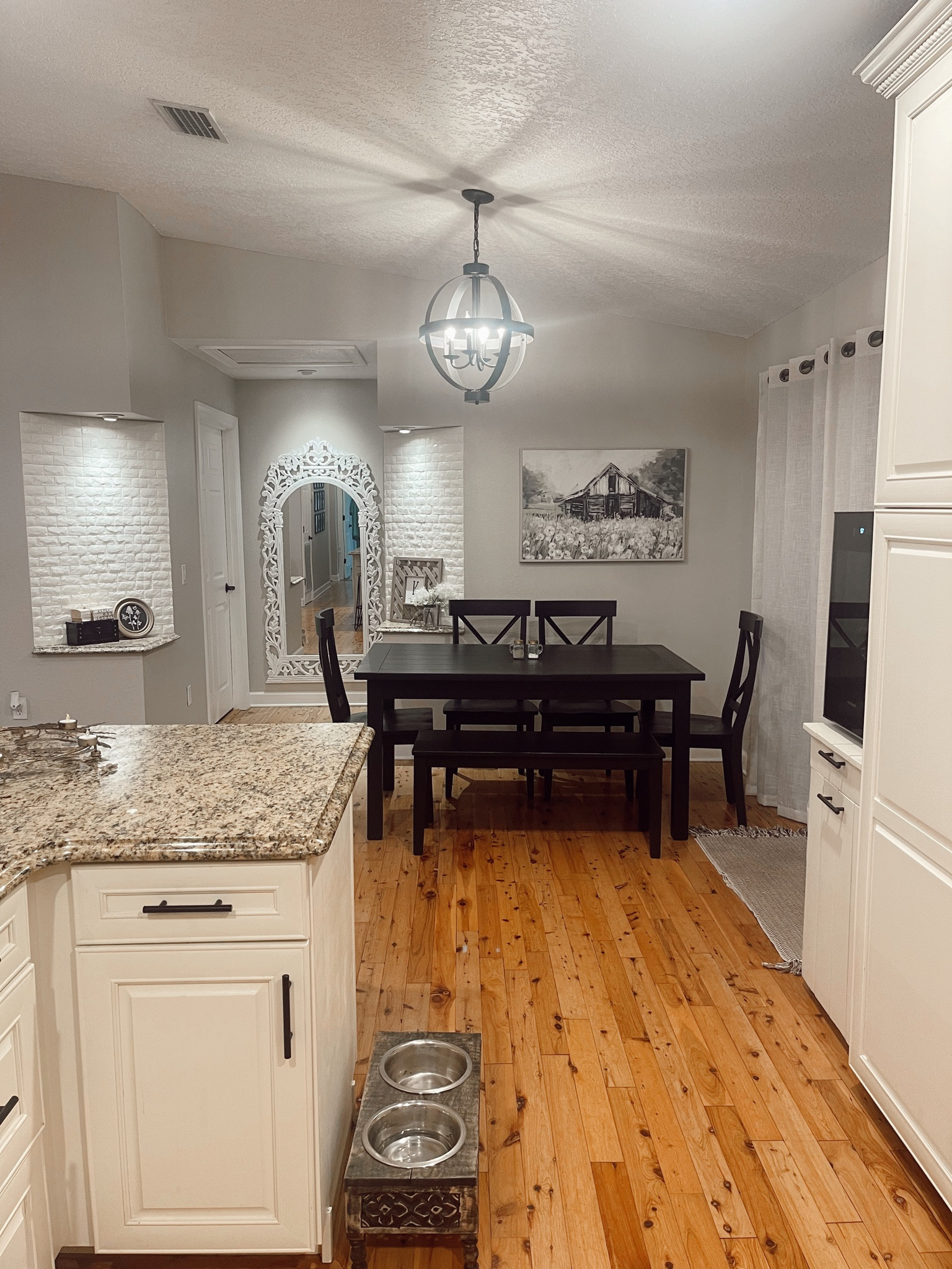 Farmhouse & cottage style dining area in our home. The table was a Facebook market place find that I chalk painted, I linked similar chairs and also the chalk paint I used that has held up beautifully! The black industrial/farmhouse/antique light fixture was from Lowe’s but I added similar options available on Amazon. The barn wall art I found at a discount store but is also linked and on Amazon as well! The large white full length mirror was an incredible Ross find, but I added similar ones from Amazon. On the nooks is a peel and stick 3 dimensional white faux brick that has been on for 2 years and still looks great! The decorative dog food holder was from home goods but I linked similar Amazon finds 

#LTKhome #LTKfindsunder50 #LTKfindsunder100