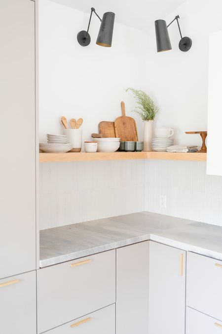 Kitchen shelf styling 

Floating shelves with vintage trays and bread boards, tall cylinder vase, dishes, mugs, wooden cake stand, wooden utensils, and sconces. 

Kitchen decor, home finds, simple styling, kitchen styling, open shelves. 

#LTKstyletip #LTKhome #LTKunder100
