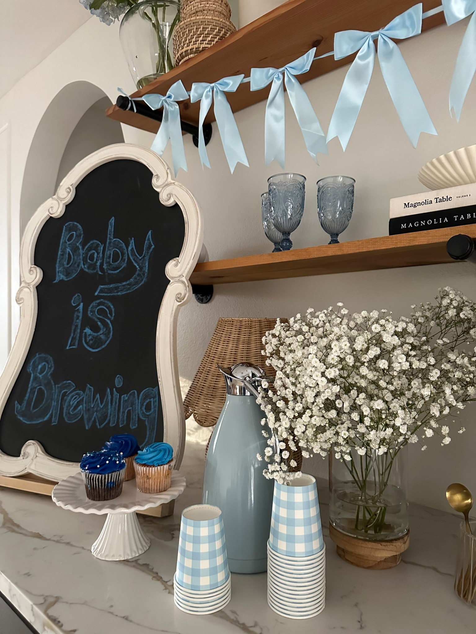 Coffee bar decorated for baby shower
Gingham coffee cups, baby blue bows and fresh flowers. 

Cafe 
Coffee bar 
Cupcake stand 
Cake 
Bakery 
Coffee 
Espresso 
Baby shower decor 
Party 
Wedding decor
Kitchen must have 
Amazon home
Vintage 
Cottage 
Home decor 
Baby blue 
Dusty blue 
Coffee carafe 
Event decor 


#LTKmomlife #LTKBaby #LTKBump