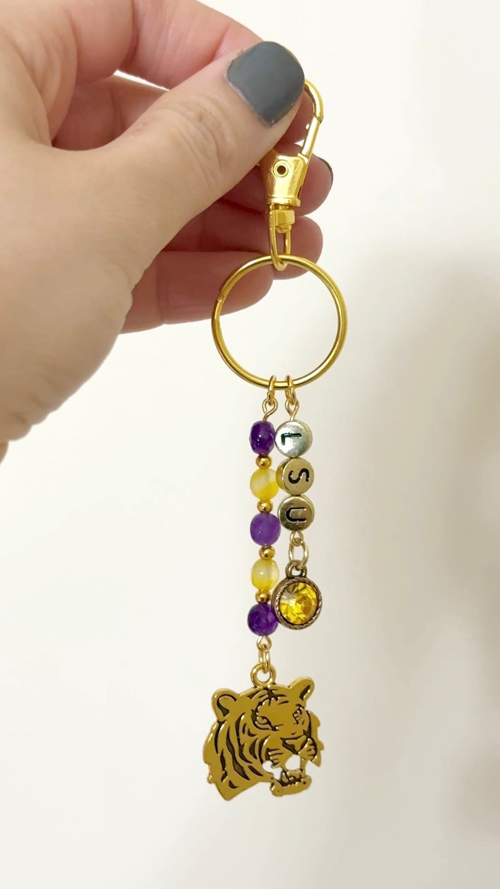 DIY keychain for the LSU fans💜Featuring purple and gold with a tiger charm🐯 

#LTKStyleTip #LTKFindsUnder50 #LTKBeauty