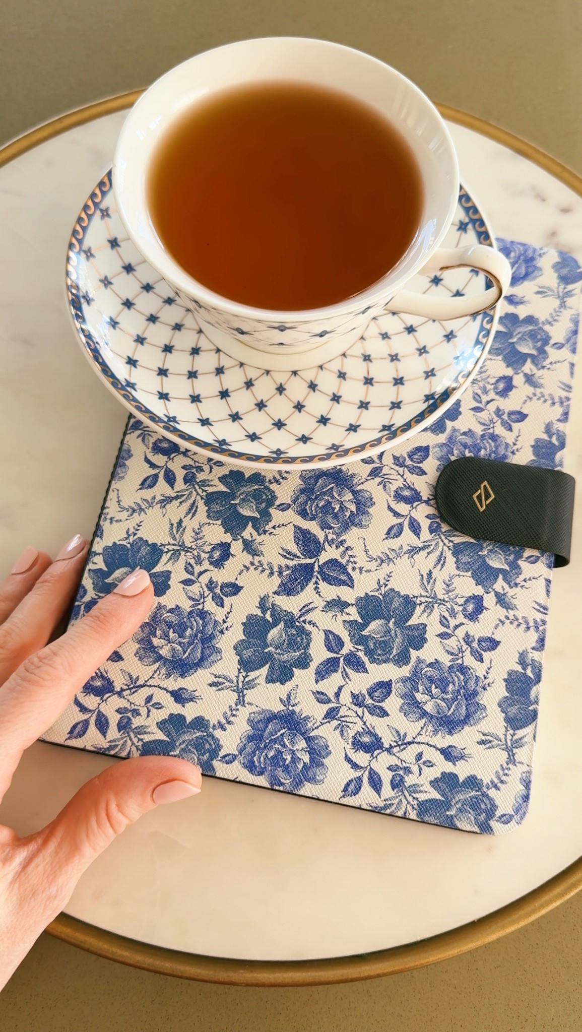 blue and white notebook and tea cup