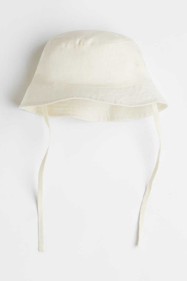 Baby Exclusive. Sun hat in soft, woven fabric with ties under chin. Lined in woven cotton fabric. | H&M (US + CA)
