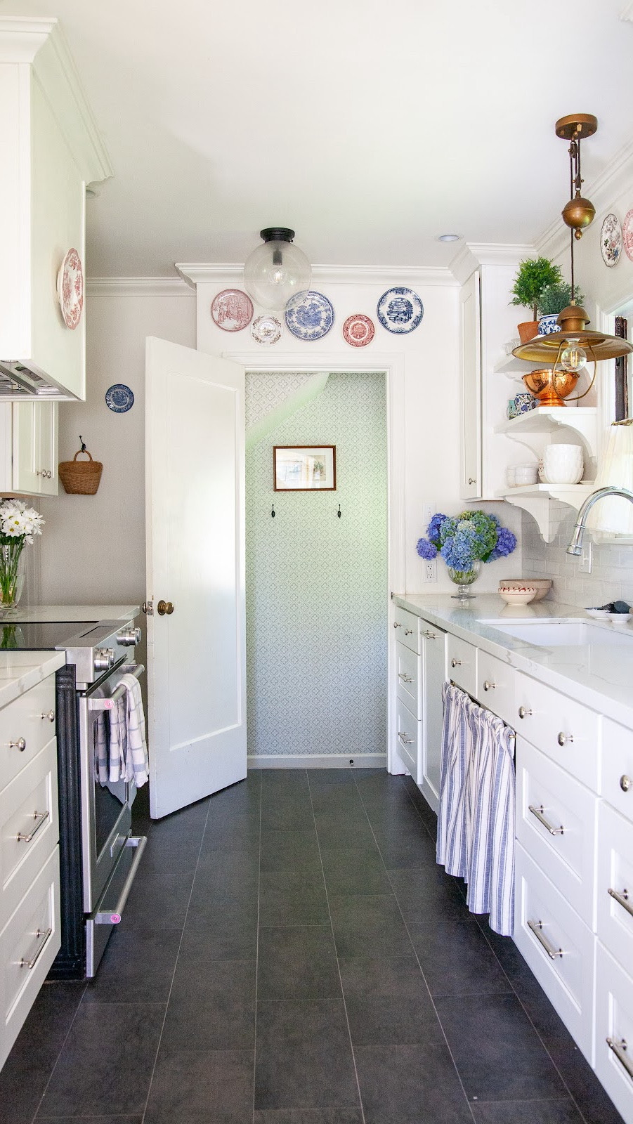 This house was a major fixer upper, and we completely redid every surface in the kitchen. On the cheap, entirely ourselves except for the countertops. But the really amazing thing is that I still love it.

How?

I chose timeless fundamentals like white cabinets and a slate look floor. The white backsplash could’ve felt boring, but I‘ve added interest with things like vintage plates on the walls. I initially did industrial look wood shelves next to the sink, which then felt really dated so I replaced with some white ones with traditional corbels. I swapped the brass hardware for a more timeless polished nickel last year. I replaced the earthy modern block print café curtain with a high-quality off-white one last year too. And of course I’ve changed the styling.

But because I stuck with basics, I’ve been able to keep the foundation the same, and still feel so grateful for my simple, small, but beautiful kitchen!

Of course, I also have detailed blog posts on both the 2019 and 2025 updates to this kitchen you can find on my blog Room Reveals page! 

#LTKHome
