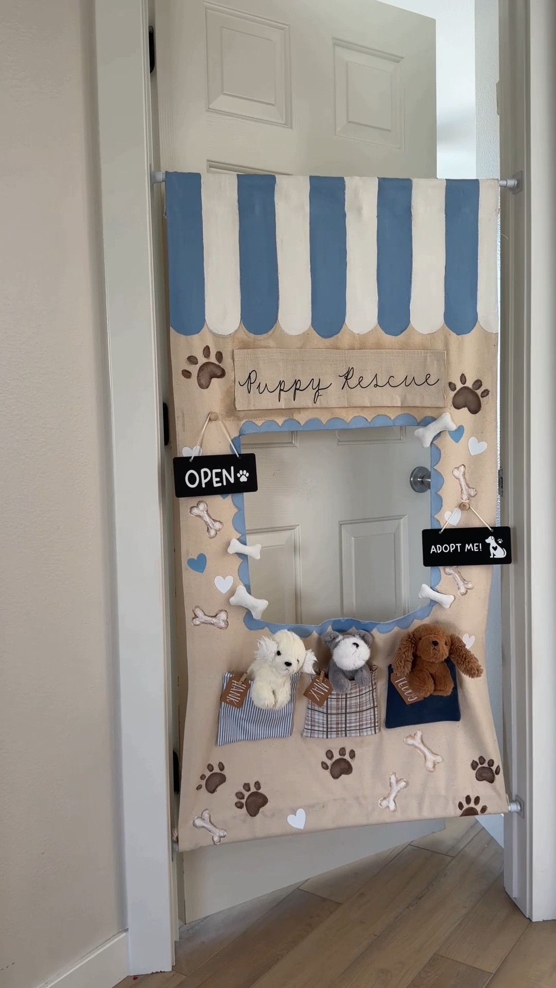 Here’s how I made our canvas door shops! ￼
You are going to start by cutting out your canvas fabric. You can go off of your door size or your child’s height! For mine, I did 4 feet x 30 inches.

Next, you are going to cut out your window. Once this is done, you are going to either use hot glue or stitch witchery to fold over all of the edges and adhere them down! This will keep your edges from fraying :) Make sure you do this to the edges inside your window too! ￼

I drew my design with pencil first! You can use fabric paint or acrylic paint that is mixed with fabric medium. Fabric medium keeps your paint from cracking!

For the pocket, I cut out canvas squares and then covered them with fabric. I just used hot glue for this part. Then I hot glued them onto the canvas! ￼

I made their signs using my Cricut, but you could also paint them on! ￼

I put a tension rod at both the top and the bottom. You can just do one at the top, but having one at the bottom keeps your pocket from folding forward!

To create the pocket to slip the tension rod into, I just folded over the canvas and hot glued it down! ￼
￼

#LTKKids #LTKBaby #LTKmomlife