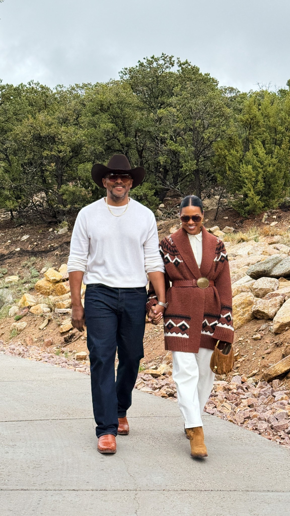 New Mexico ootd: white barrel jeans, white silk top, western cardigan, oversized red & gold belt, brown handbag, and cowboy boots. 

#LTKOver40 #LTKStyleTip