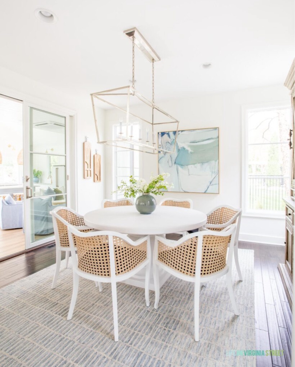 I love how open and airy our dining room is! I’ve styled our dining room with a  round white table, cane dining chairs, a gorgeous blue vase, faux greenery, a linear chandelier and fun abstract art to the room as well! Linked other items in our dining room including a distressed wood buffet, our neutral blue area rug and fun wooden cheese boards that I hung on the wall! 

#LTKunder50 #LTKunder100

dining room, blue and white decor, neutral decor, pb inspired dining room, dining room table, dining room chairs, dining room rug, dining room buffet 

#LTKsalealert #LTKhome #LTKstyletip