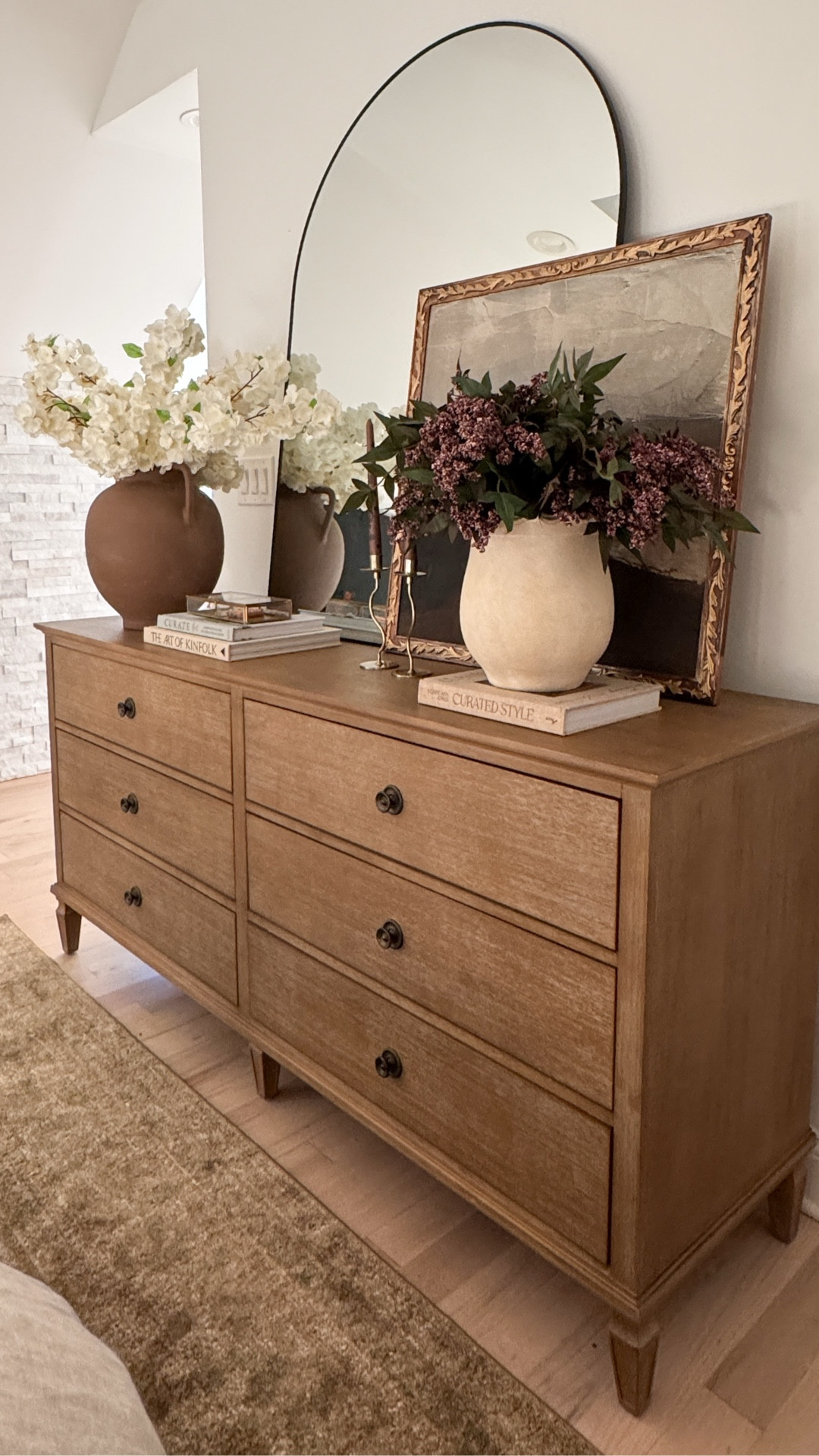 A timeless dresser setup I’ll never get tired of 🤎
I styled this wood dresser with an arched mirror, ceramic vases, and neutral faux florals to create that cozy, modern organic feel I love.
Layering books, art, and texture always makes the space feel more curated and designer-inspired. ✨

Shop the look below ⬇️
#BedroomDecor #WoodDresser #ArchedMirror #NeutralHome #ModernOrganicHome #LTKHome #DesignerLookForLess #CozyBedroom #HomeStyling #LTKFinds


#LTKHome #LTKSaleAlert #LTKSeasonal