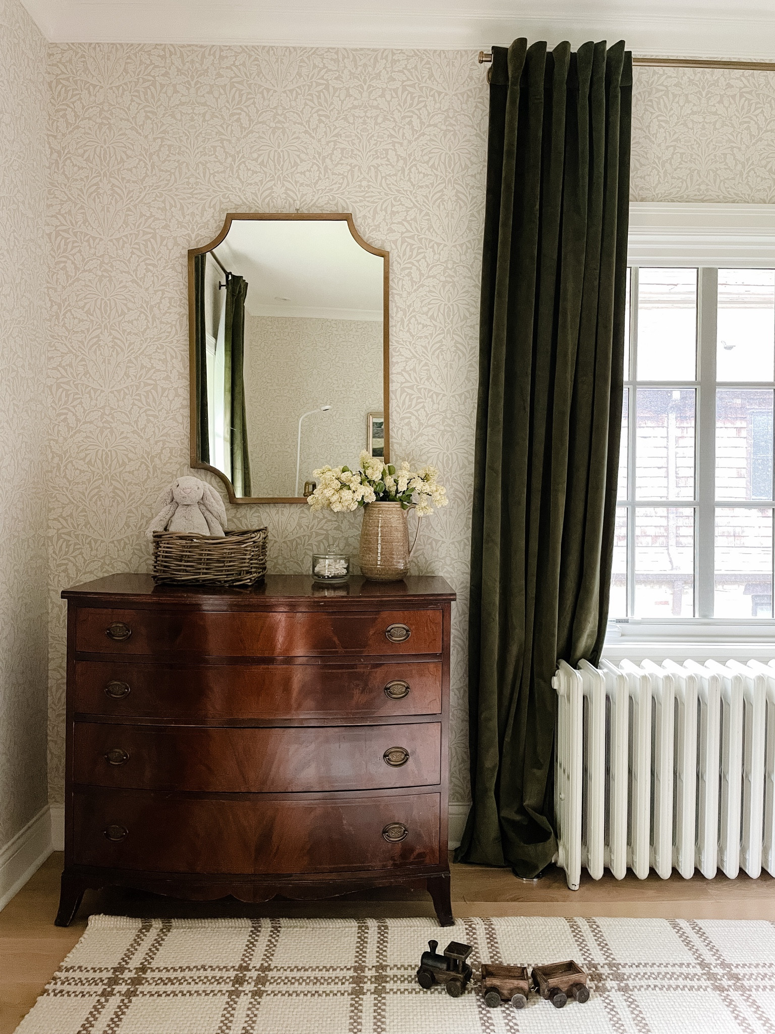 Nursery details, green velvet curtains. Gold curtain rods, brass mirror, plaid rug