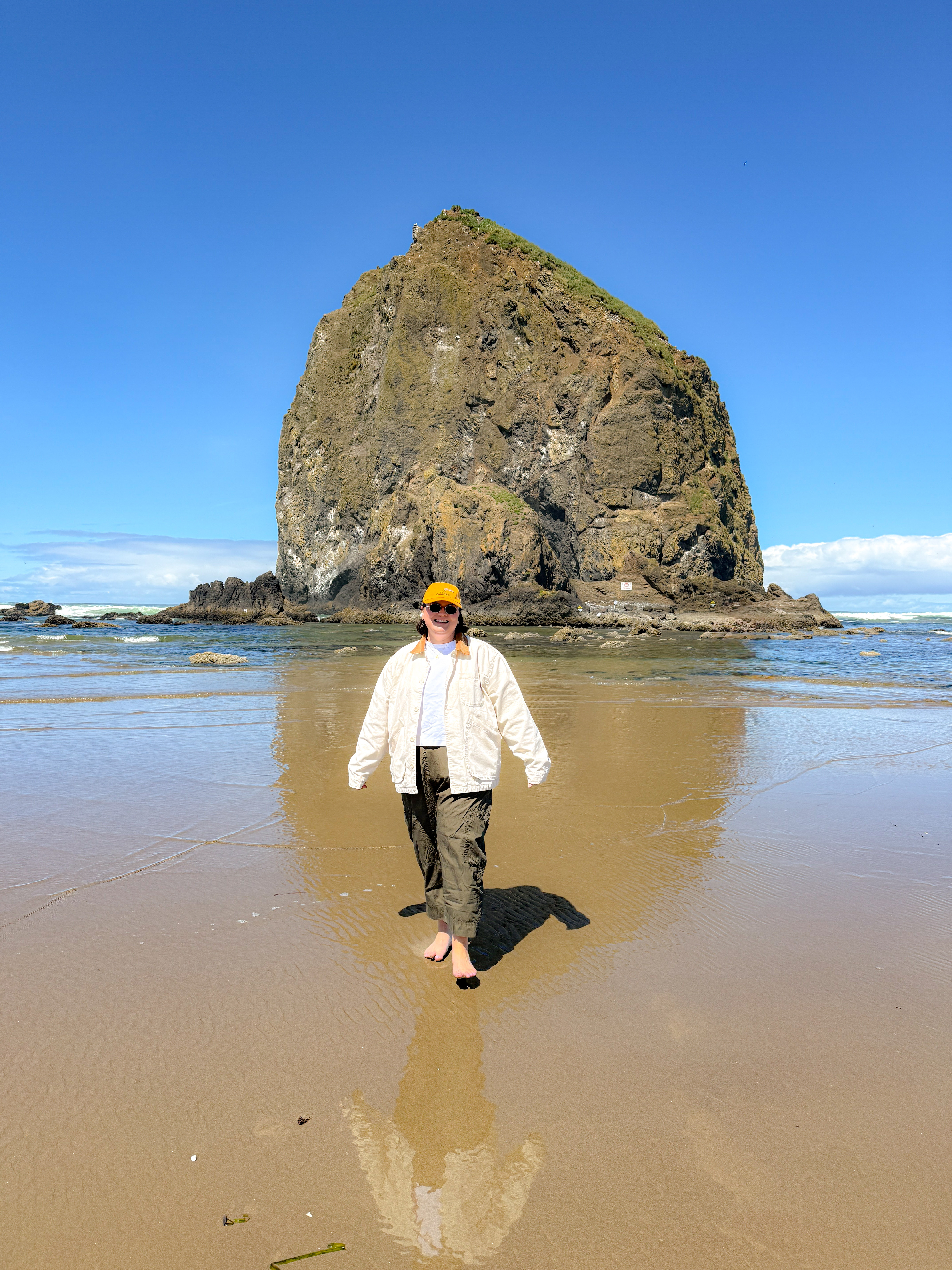 Layered a white chore jacket (PSST it's men's!), love that pop of brown on the collar, over a basic white tee and olive cargo pants for a beach walk that turned into a full photo op. The jacket's doing double duty as sun protection and outfit-maker, and the cap pulls the orange through. Barefoot in the sand, exactly where I wanted to be.
Hashtags

#LTKtravel #LTKfindsunder100 #LTKstyletip #cannonbeach #haystackrock #oregoncoast #beachoutfit #chorejacket #cargopants #pnwtravel 

 