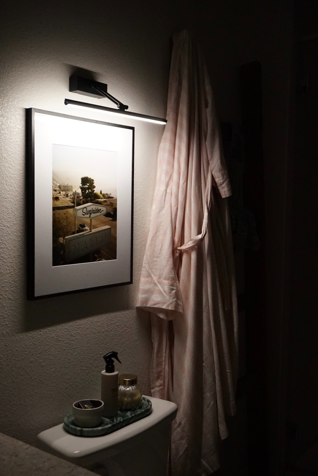 Renter-friendly bathroom decor idea! I love shelves or frames in this area of a bathroom, and the picture light adds such a vibe. I linked my products and tools I used to complete this mini-project!  

 #LTKHome #LTKFindsUnder50