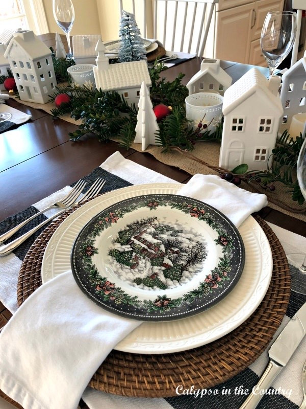 Christmas village themed table setting with black and white plates and white ceramic houses.

#LTKHoliday #LTKSeasonal #LTKHome
