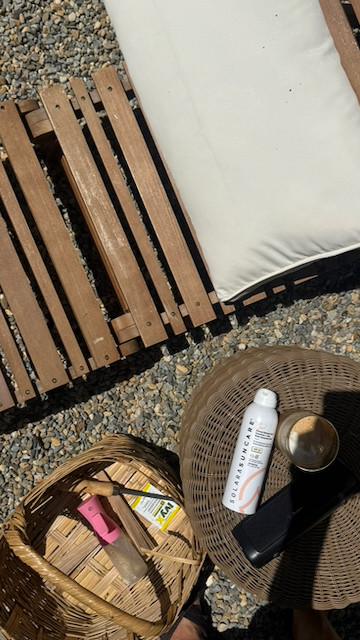 Teak lounge chair on the gravel patio with my go-to basket of sunscreen, bug spray, and everything else I need before I sit down outside. Summer afternoons start here. 

 #LTKSeasonal #LTKSwim #LTKBeauty