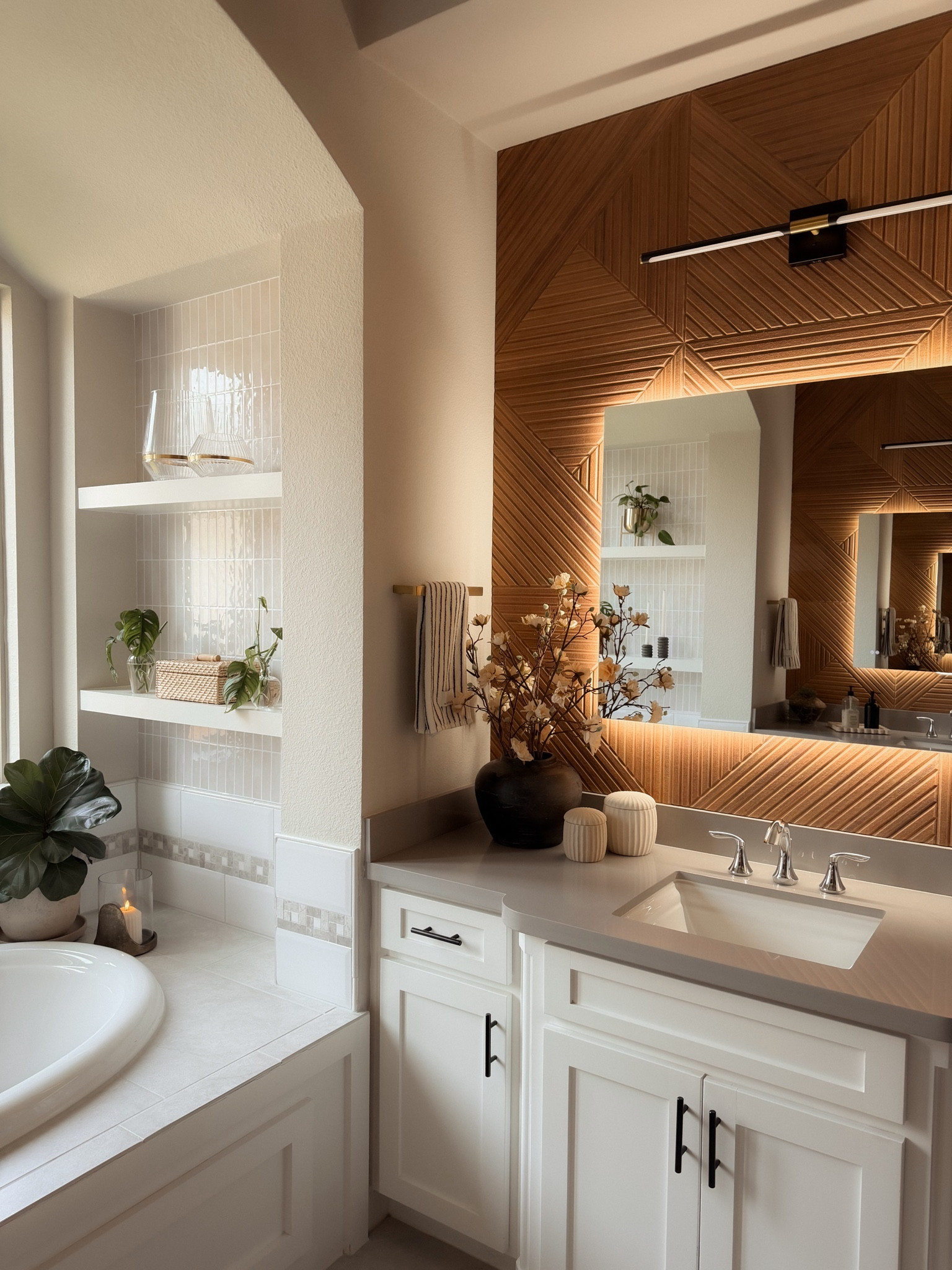 Our master bathroom refresh is officially one of my favorite home upgrades 🤍✨ This no-demo bathroom renovation completely transformed our builder-grade bathroom into a warm, modern, spa-like space.

We updated the bathroom vanity area, added faux wood accent wall paneling, modern bathroom lighting, neutral decor, and elevated bathroom accessories for a clean organic modern look. I love how the warm wood tones mixed with white cabinetry create that cozy, high-end bathroom aesthetic.

Perfect for anyone planning a bathroom remodel, master bathroom update, DIY bathroom upgrade, vanity refresh, or spa-inspired bathroom decor.

Linking all the bathroom decor, lighting, mirrors, hardware, and styling pieces we used 👏🏼

#bathroomremodel #masterbathroom #bathroomrefresh #diybathroom #homerenovation #modernbathroom #ltkhome 

 #LTKdayinmylife #LTKmomlife #LTKSaleAlert