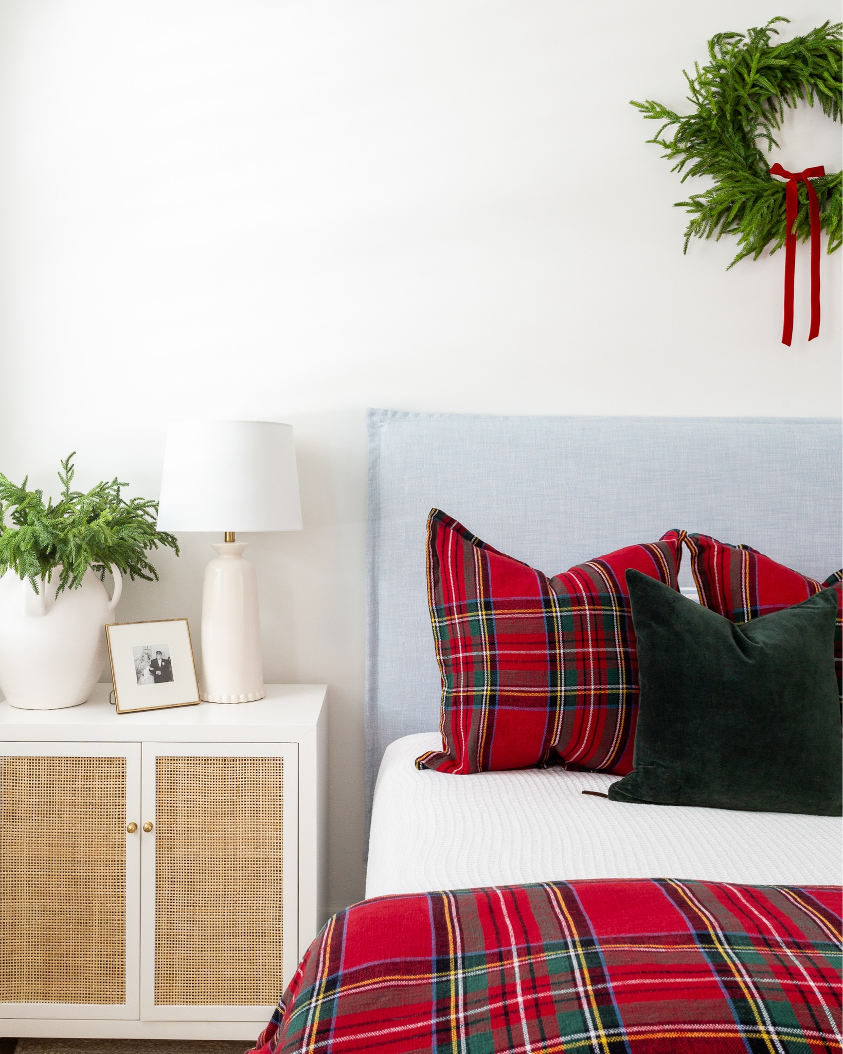 Christmas bedroom with vaulted ceilings, a light blue linen bed, white and red plaid bedding, dark green velvet pillows, a wreath with red velvet bow above the bed, bead chandelier, rattan nightstands, a rattan bench, and white jute rug. See our full Christmas home tour here: https://lifeonvirginiastreet.com/2024-christmas-home-tour/. #ltkholiday #ltkhome #ltksalealert #ltkfindsunder50 #ltkfindsunder100 #ltkseasonal #ltkstyletip 

#LTKHome #LTKSaleAlert #LTKHoliday