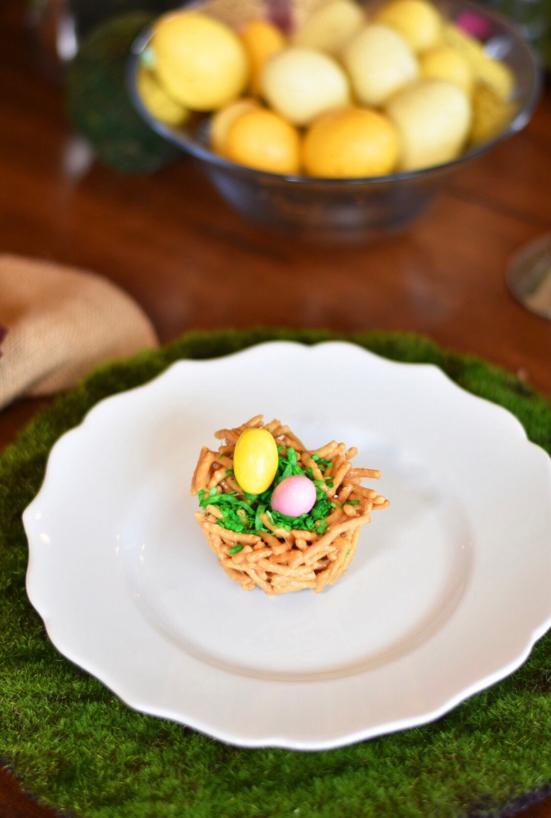 Easter Bird’s Nests

Ingredients:

3 cup mini marshmallows
3 TBSP unsalted butter
1/2 tsp vanilla
4 cup dry chow mein noodles
small candies, jelly beans, m & m’s, etc.
1 cup of coconut
Green food coloring

Directions:

Over low heat, melt the marshmallows and butter in a large saucepan.
Once melted, stir in the vanilla, then the chow mein noodles.
Liberally spray muffin tin with cooking spray like PAM.
Using your hands, press the noodles into the muffin tins to create nests.
Let cool and harden in the fridge for at least one hour.
Dye coconut to create grass. Fill the nests with the “grass” and add your favorite egg shaped candy to create the eggs. Jelly beans work great! I used egg shaped Smarties.