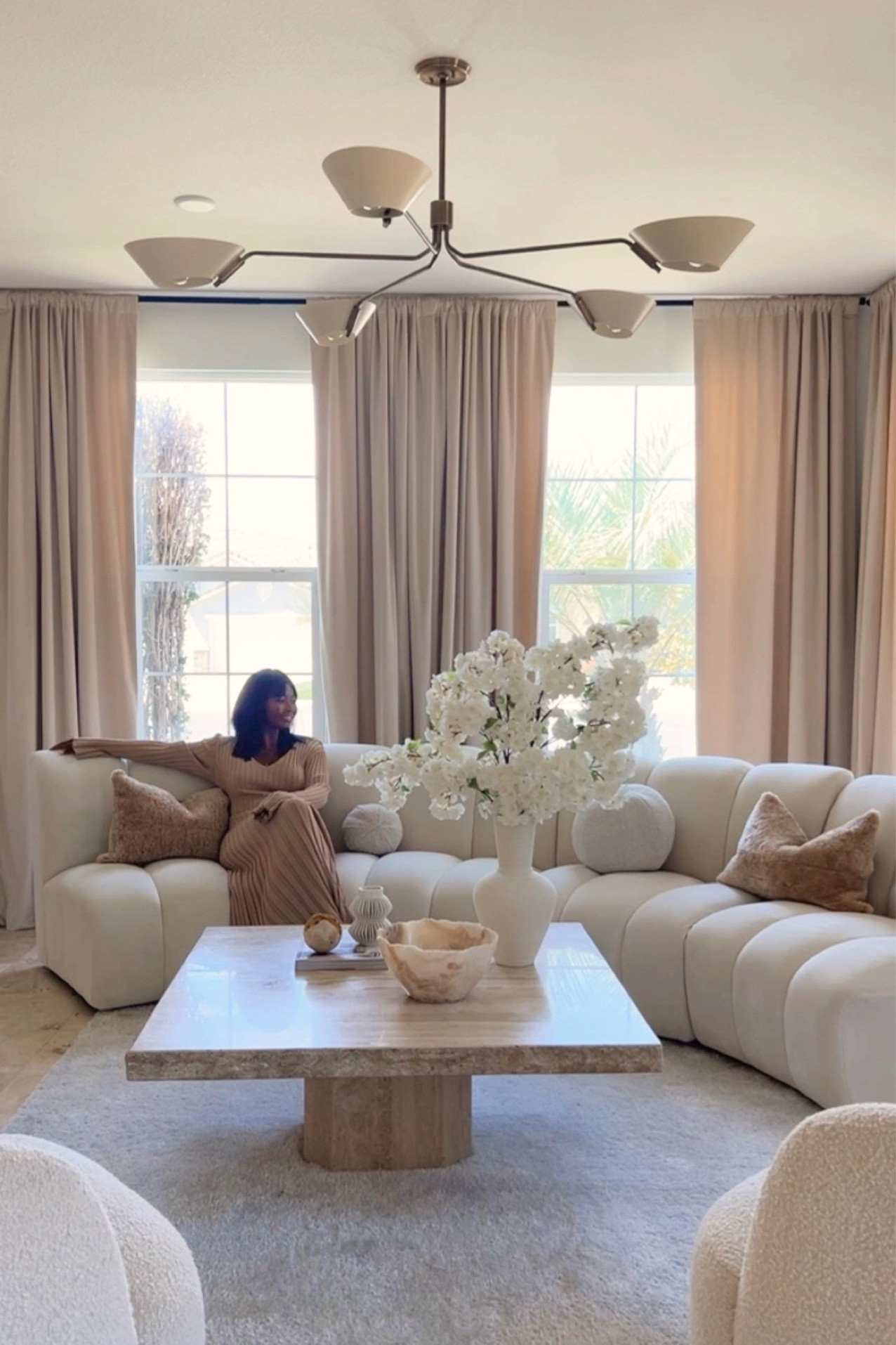 Lounging in my chic living room with some of my favorite pieces from @cb2: vases @crateandbarrel: shearling pillows & @luluandgeorgia: chandelier
Coffee table decor, coffee table styling, neutral home decor, neutral home style #flowerdecorations 

#LTKhome
