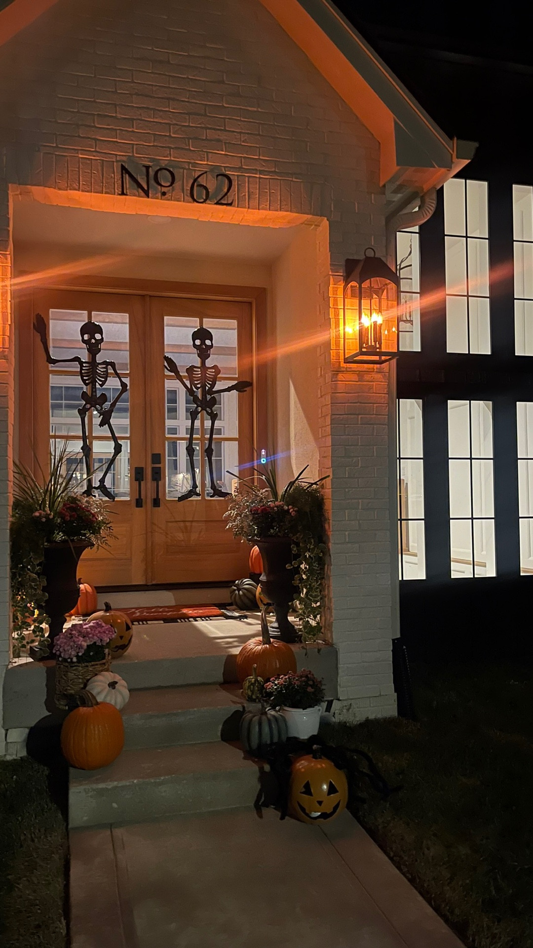 Front porch Halloween Decor! Skeletons and pumpkins! Black outdoor sconce lantern with flame flickering lights! 

#LTKHome #LTKSeasonal