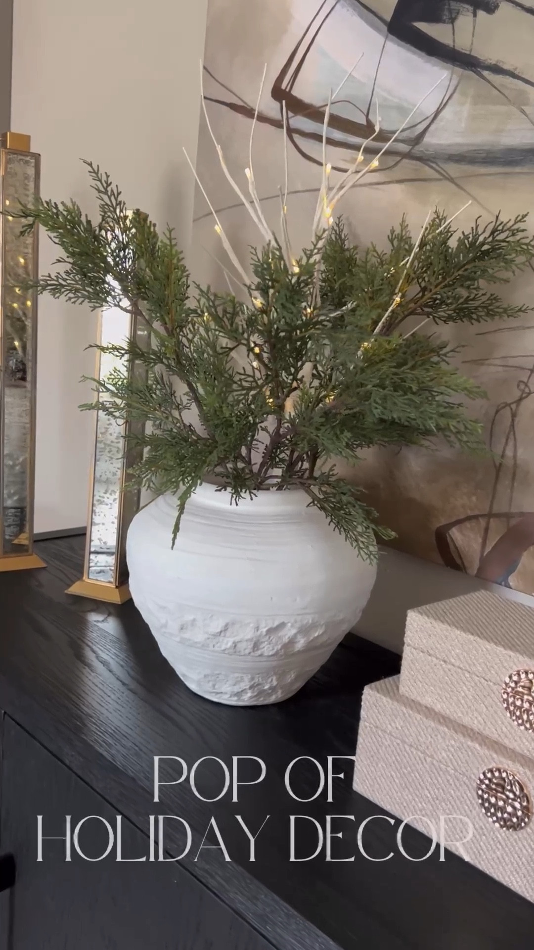 Added a pop of Christmas spirit to our sideboard table with faux pine stems, and a battery operated tree. Designing tip: depending on the depth of the vase, the light up tree might drop too low. I added a small empty box I wasn’t using to help prop the tree up to still have height and blend with the stems  

#LTKhome #LTKSeasonal #LTKHoliday