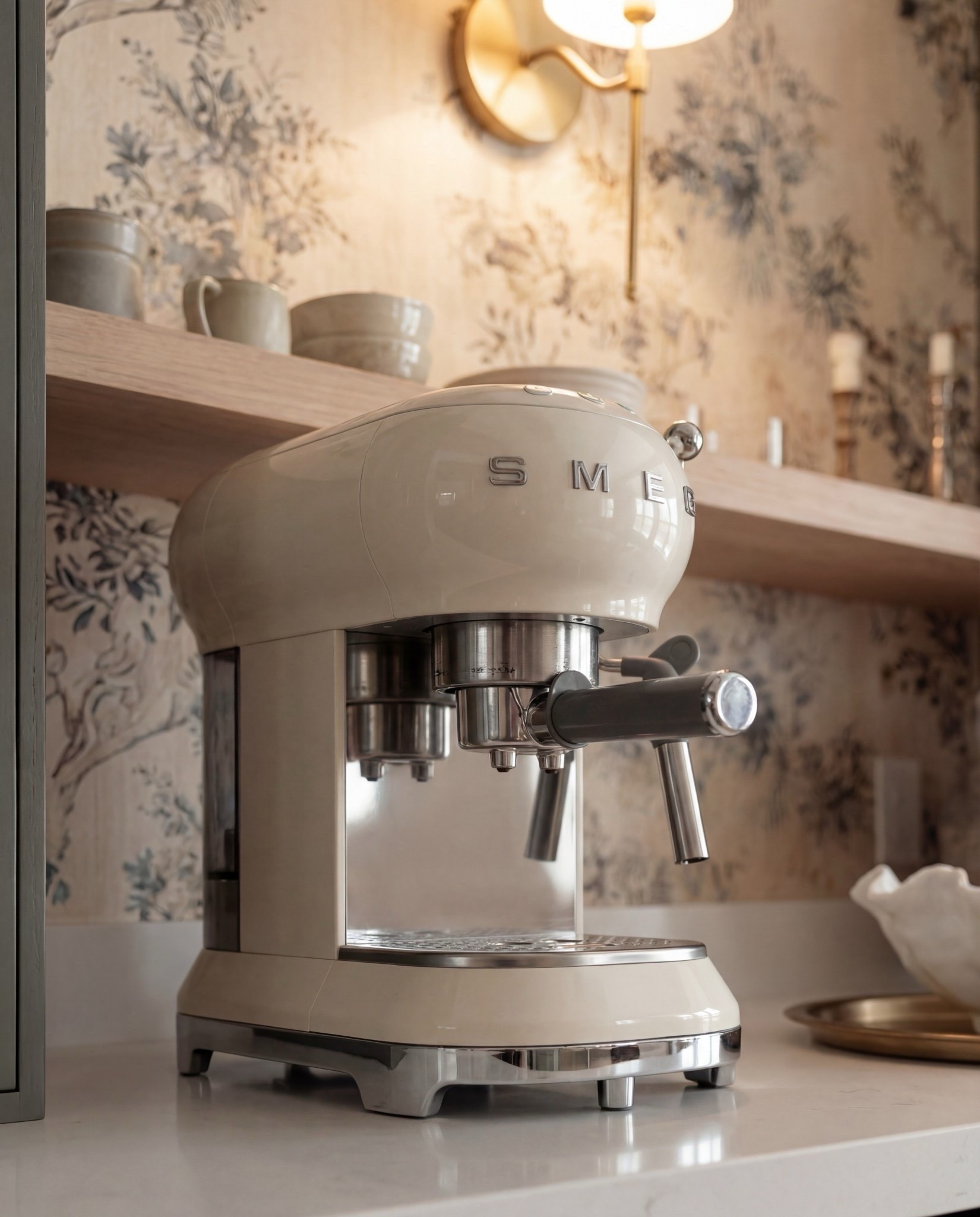 Shop the Look:
• Muted green paneled cabinetry
• Brass cabinet pulls + drawer handles
• Fluted panel tall cabinets
• Glass-front upper cabinets
• Floral wallpaper (neutral botanical pattern)
• Brass wall sconce with white shade
• Light wood floating shelf
• White espresso machine
• Built-in beverage fridge
• Built-in wine fridge
• Clear wine glasses + stemware set
• Stacked ceramic plates + bowls
• Neutral ceramic mugs
• Sculptural ceramic bowl (organic shape)
• Large ceramic vase (earthy tones)
• Light wood flooring
• Vintage-style runner rug (soft neutral pattern)

#LTKHome #LTKSaleAlert