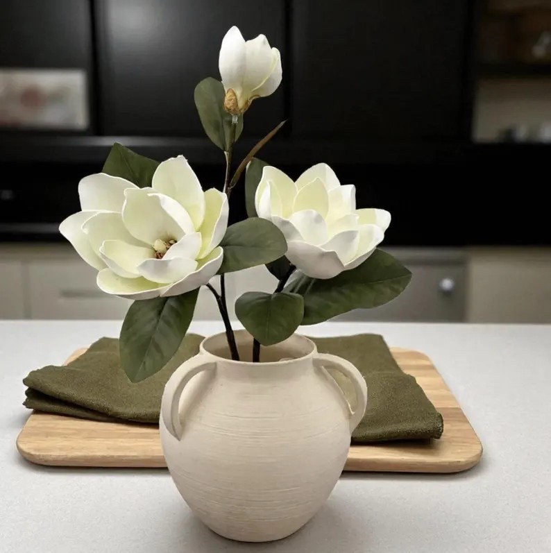 Create effortlessly elegant arrangements with this ultra-realistic magnolia stem from GarlandGatherings 🤍 Made with soft EVA foam flower heads, this bendable 28” stem is easy to style and looks beautifully lifelike from every angle. With layered white blooms, natural brown centers, and green accents, it’s perfect for DIY bouquets, wreaths, centerpieces, or seasonal home décor. Sold individually so you can customize your look, this magnolia stem is a versatile staple for any craft or floral project.

#LTKhome #DIYDecor #FloralSupplies #MagnoliaStem #CraftProjects #HomeStyling #EtsyFinds

#LTKHoliday #LTKHome #LTKSeasonal