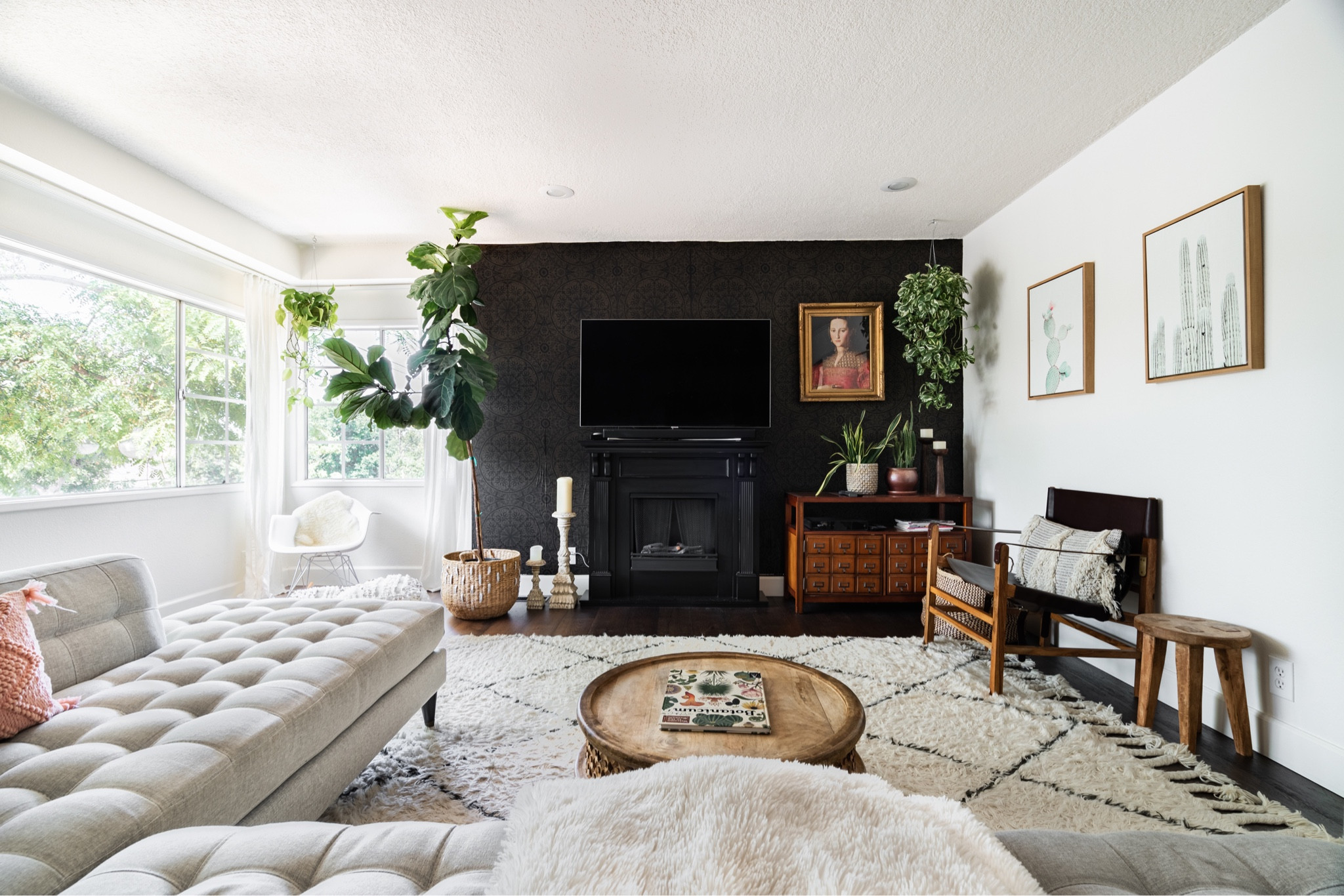 To disguise the TV in my living room I added a black wallpaper wall.  With a fun vintage print and lots of plants this living room is a cozy place to watch my favorite shows.  #livingroom #livingroomdecor #sectional #art #mediaroom 

#LTKunder100 #LTKunder50 #LTKhome
