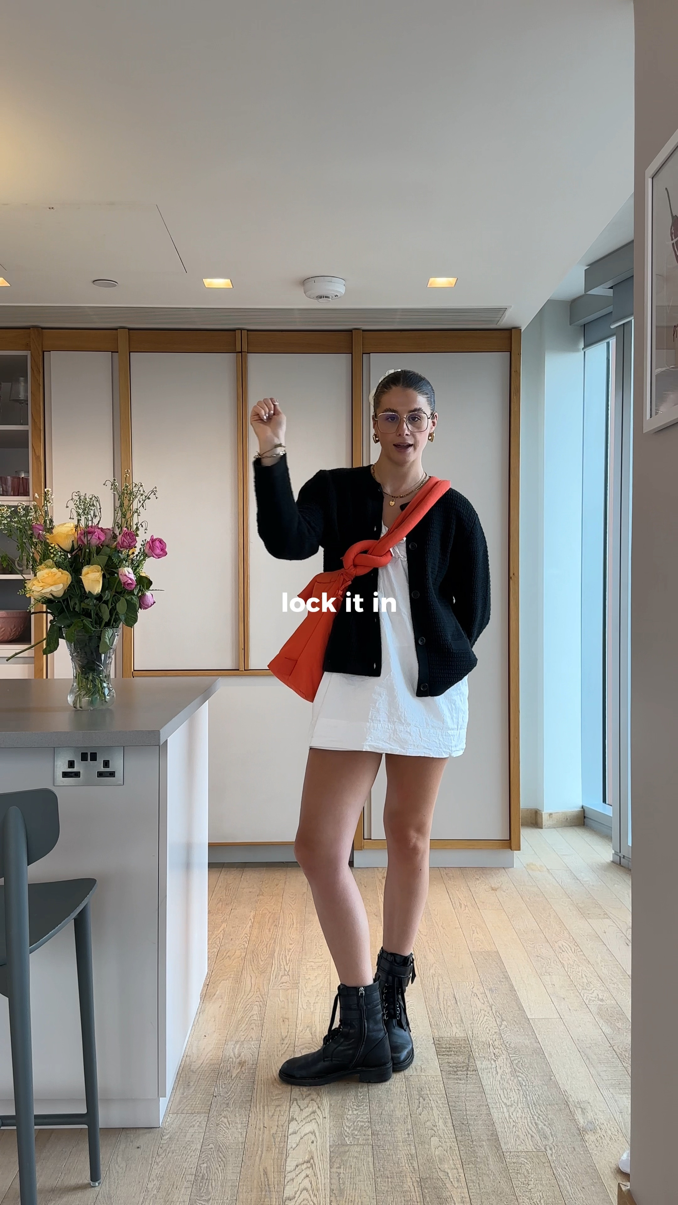 Uniqlo black knit cardigan, gold jewellery heart earrings, white mini dress tie up blouse ganni style, layering, black biker style boots doc martens gold frame glasses summer transitional uk summer weather outfit inspo

#LTKsummer #LTKuk #LTKstyletip