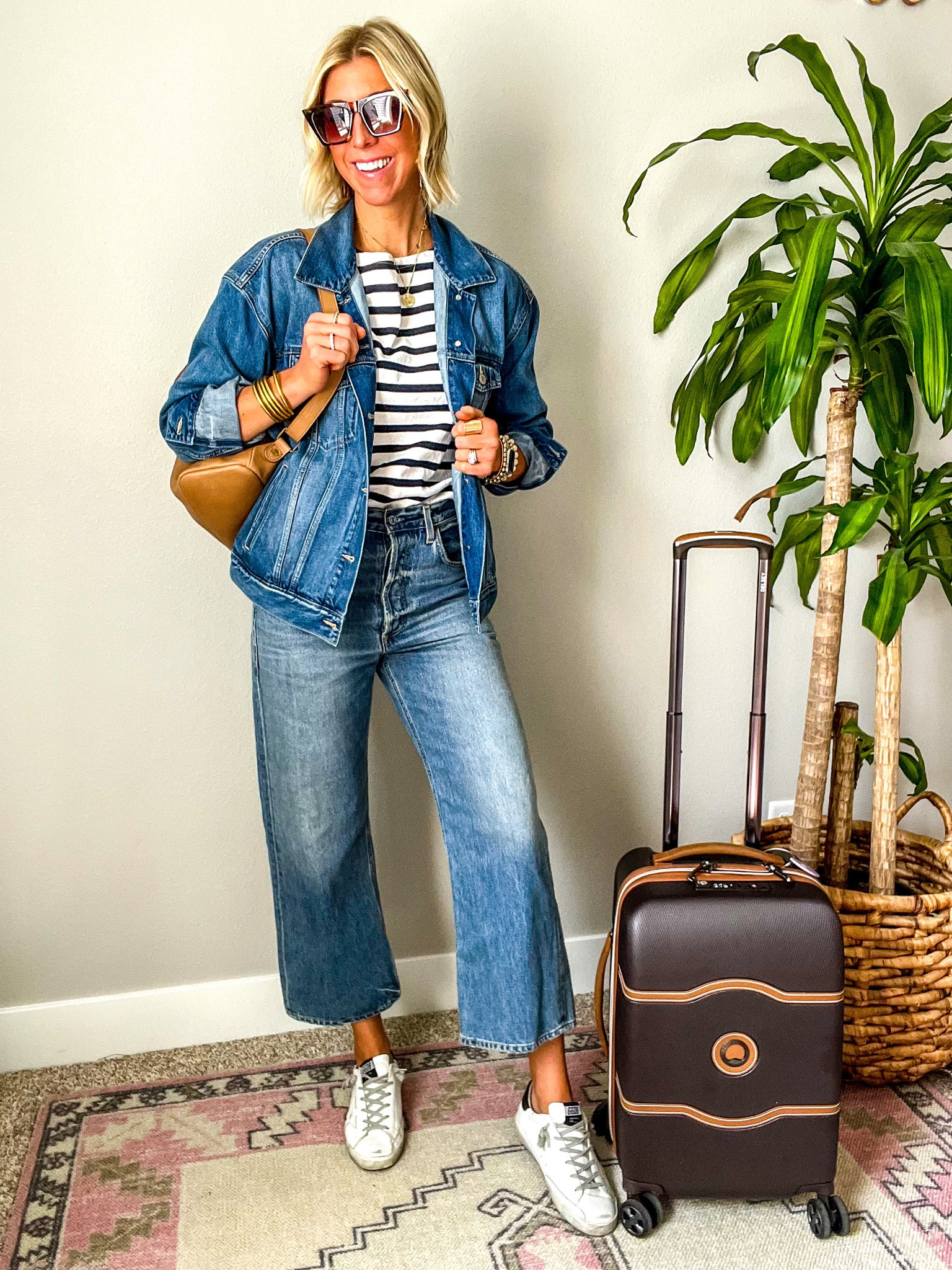 Travel day style including cropped jeans, navy blue and white stripe shirt, oversized denim jacket, leather backpack, and sneakers #sarahkellystyle #travelstyle #traveloutfit

#LTKstyletip #LTKtravel #LTKSeasonal