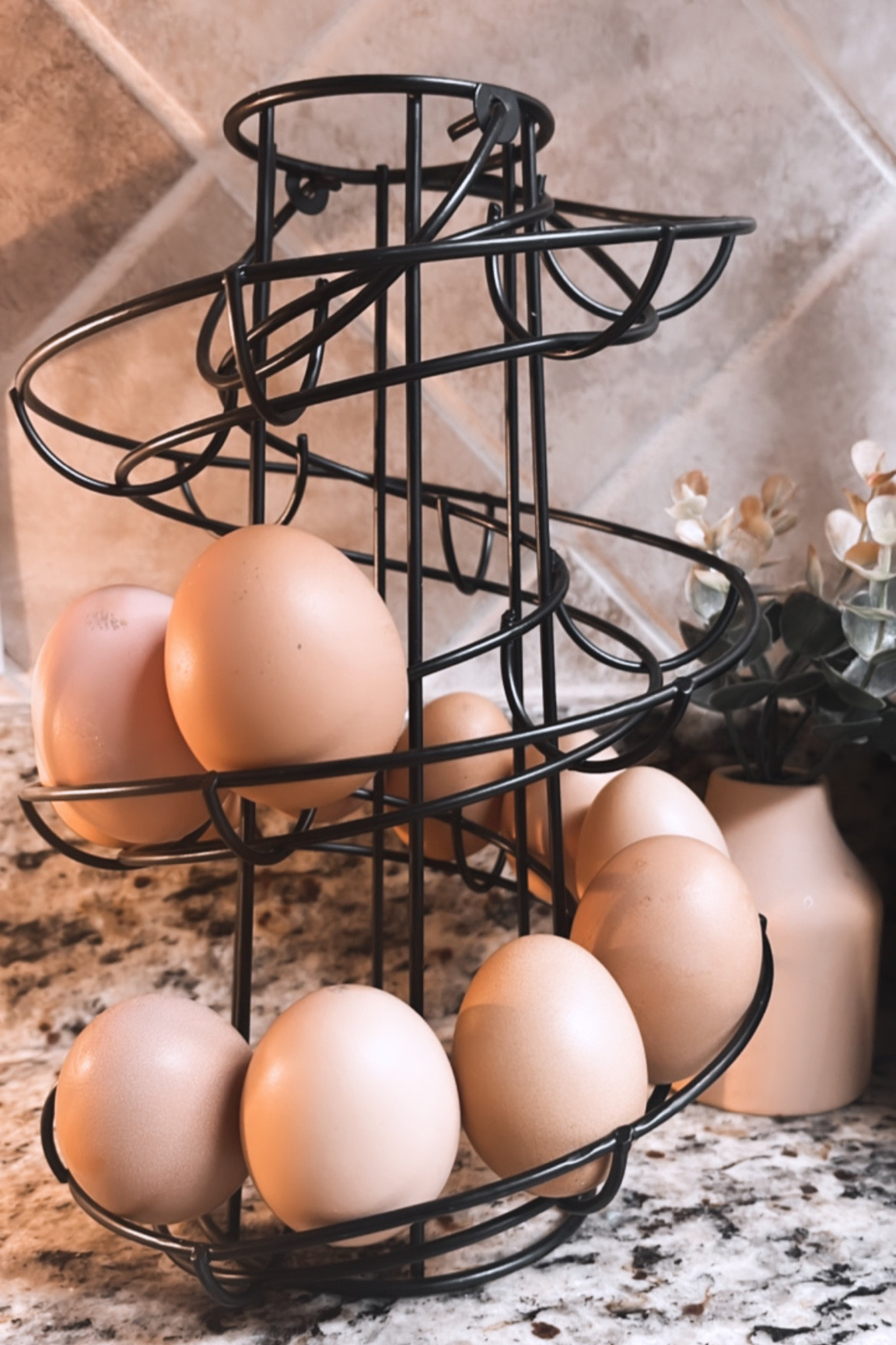 This egg skelter is a brilliant way of storing and displaying your fresh eggs in date order. It allows you to take the oldest eggs first. This egg dispenser holds up to 22 eggs, its compact and spiral design is perfect for decorative and indoor use. The spiraling metal slide that wraps around this metal rack is designed to hold your collection of eggs and keep them easily accessible when you're cooking or baking. When you take one egg from the line-up, the sloping nature of the metal slide causes the next egg in line to roll forward so your fresh eggs always stay within easy reach. A small handle at the top makes moving this stand from location to location both easy and convenient, and the spiraling style gives this egg rack a touch of modern flair. Display and organize your eggs like never before with this freestanding egg dispenser rack.

#LTKunder50 #LTKSeasonal #LTKhome
