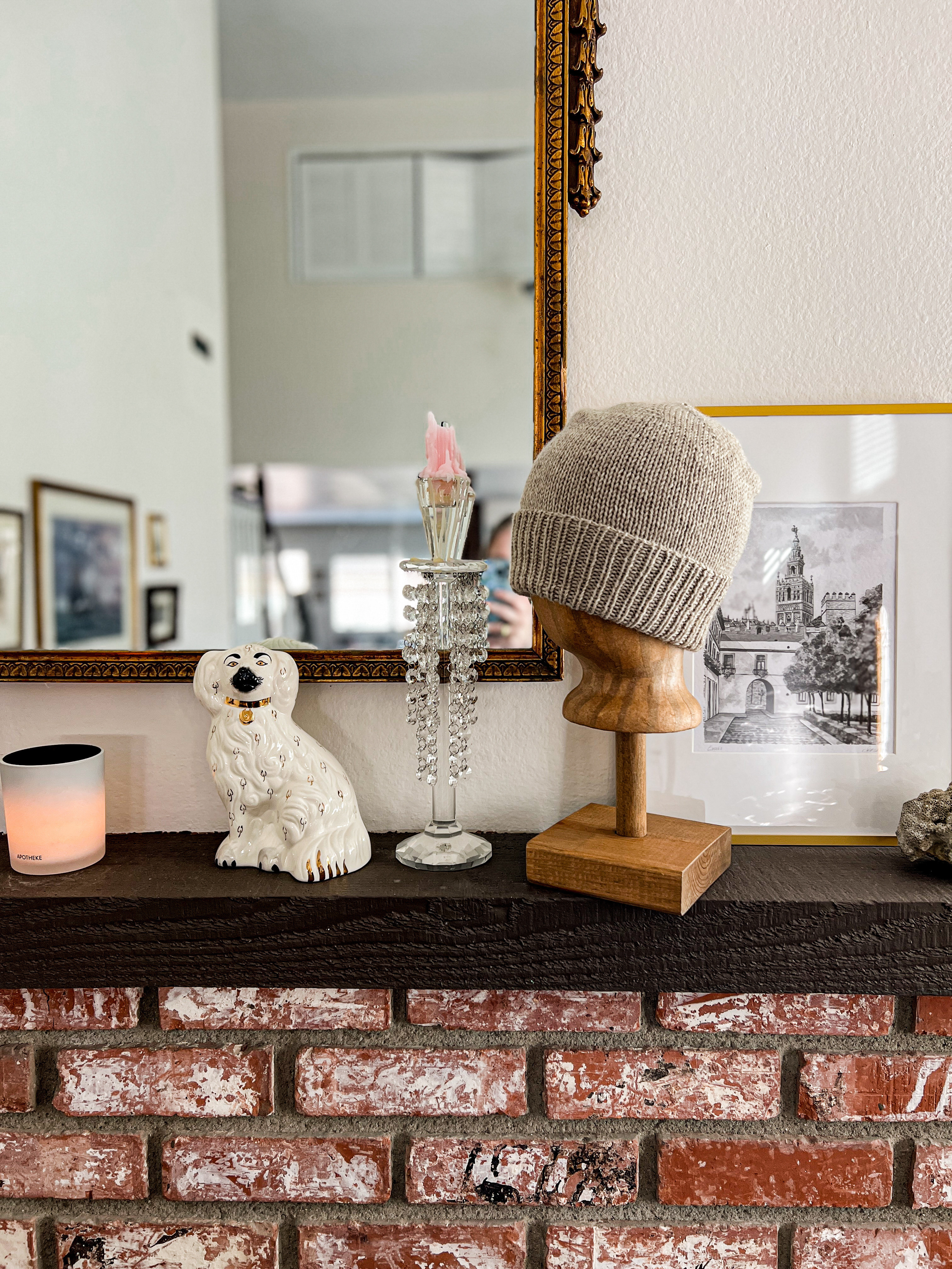 Eclectic bric-a-brac. Some vintage candlesticks, a Staffordshire dog, my favorite candle, and the prettiest gold mirror I ever did see.  

 