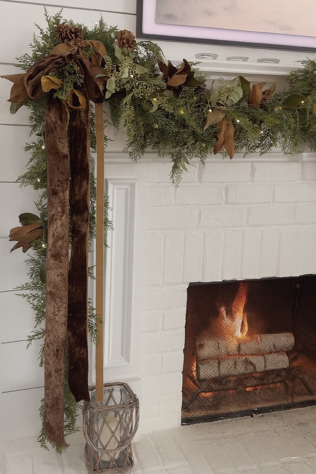 Natural holiday mantel with cedar garland, brown velvet ribbon, magnolia leaves and pine cones perfect for before Thanksgiving and into Christmas. 🤎