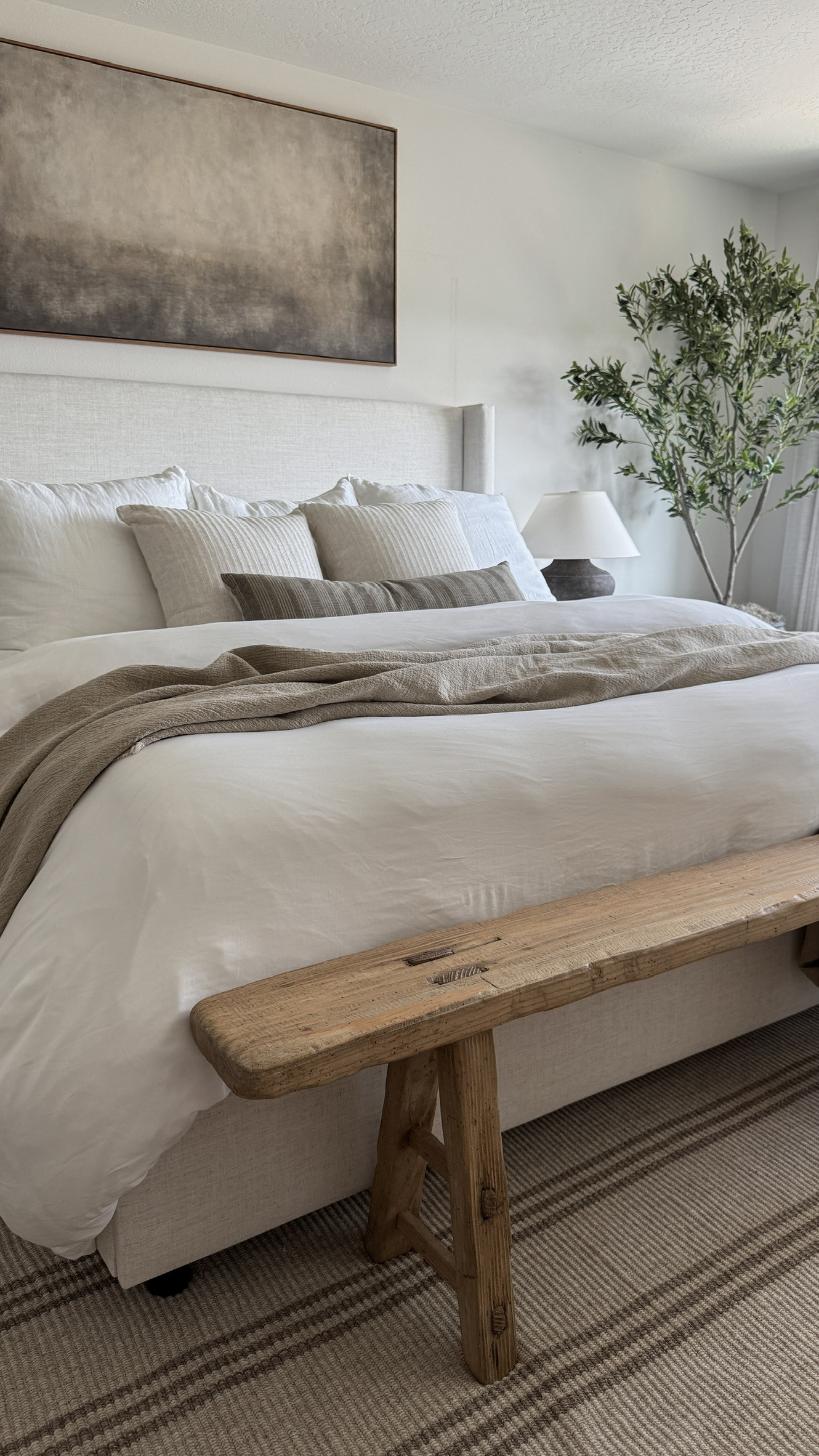 This corner of my organic modern bedroom is feeling so calm and grounded lately. The layered neutral bedding, textured striped rug, and warm wood bench add just the right amount of earthy contrast to the crisp upholstered bed. A perfect setup if you're going for that neutral bedroom aesthetic with a cozy, elevated vibe. 

 

#LTKHome