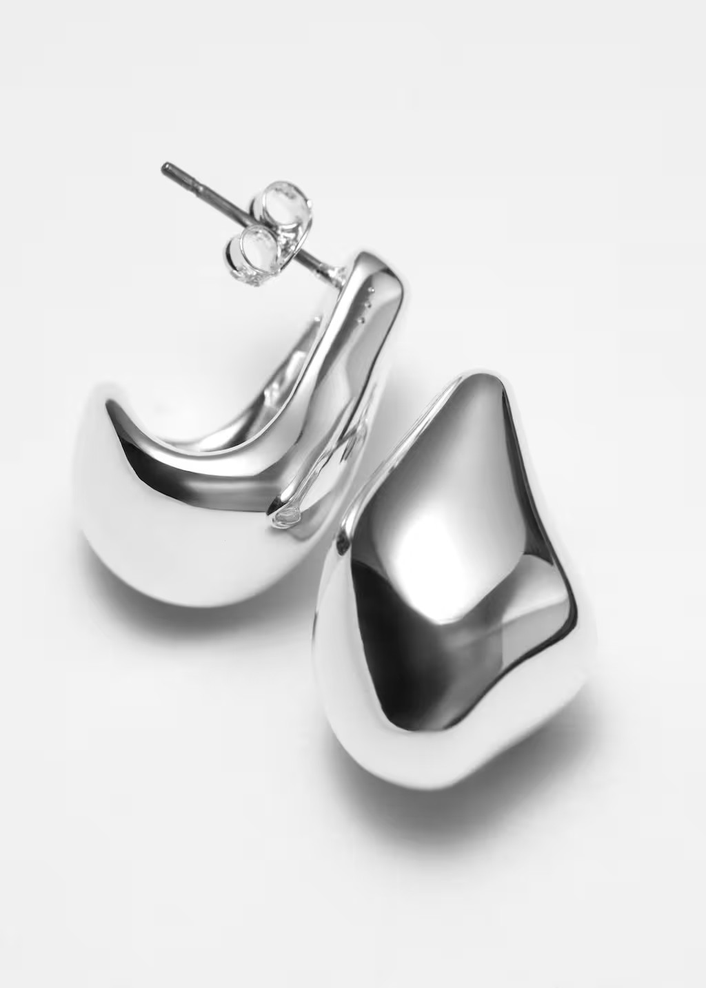 These earrings have a rounded, sculptural shape that curves under the earlobe and are crafted fro... | & Other Stories - US