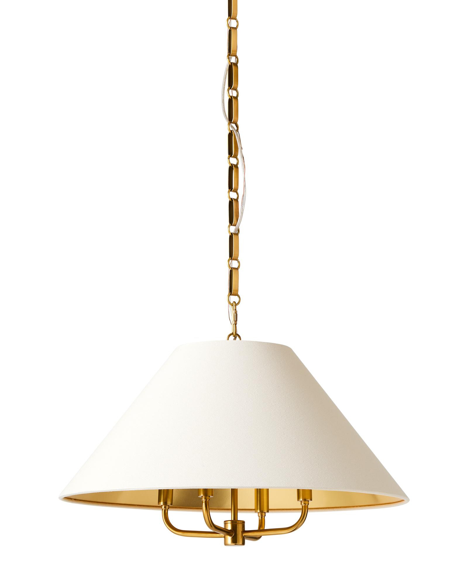 A gleaming brass base and linen shade lined with gold. It casts a shimmering light below. | Serena and Lily