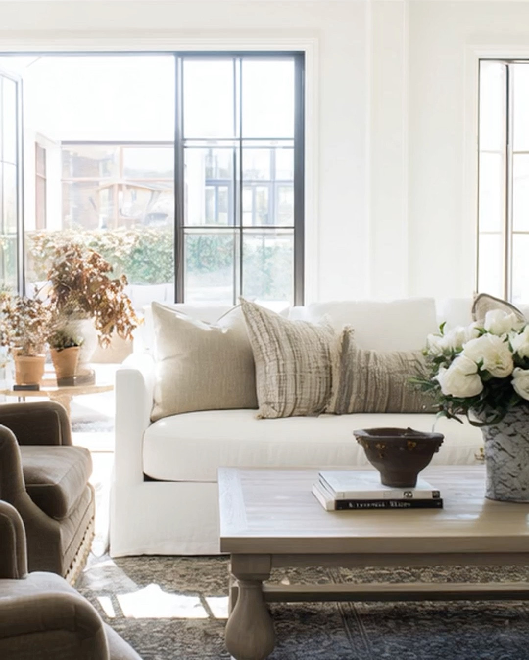 Neutral & transitional living room, skirted white couch, brown accent chairs & grey oak coffee table  

#LTKFamily #LTKFindsUnder100 #LTKHome