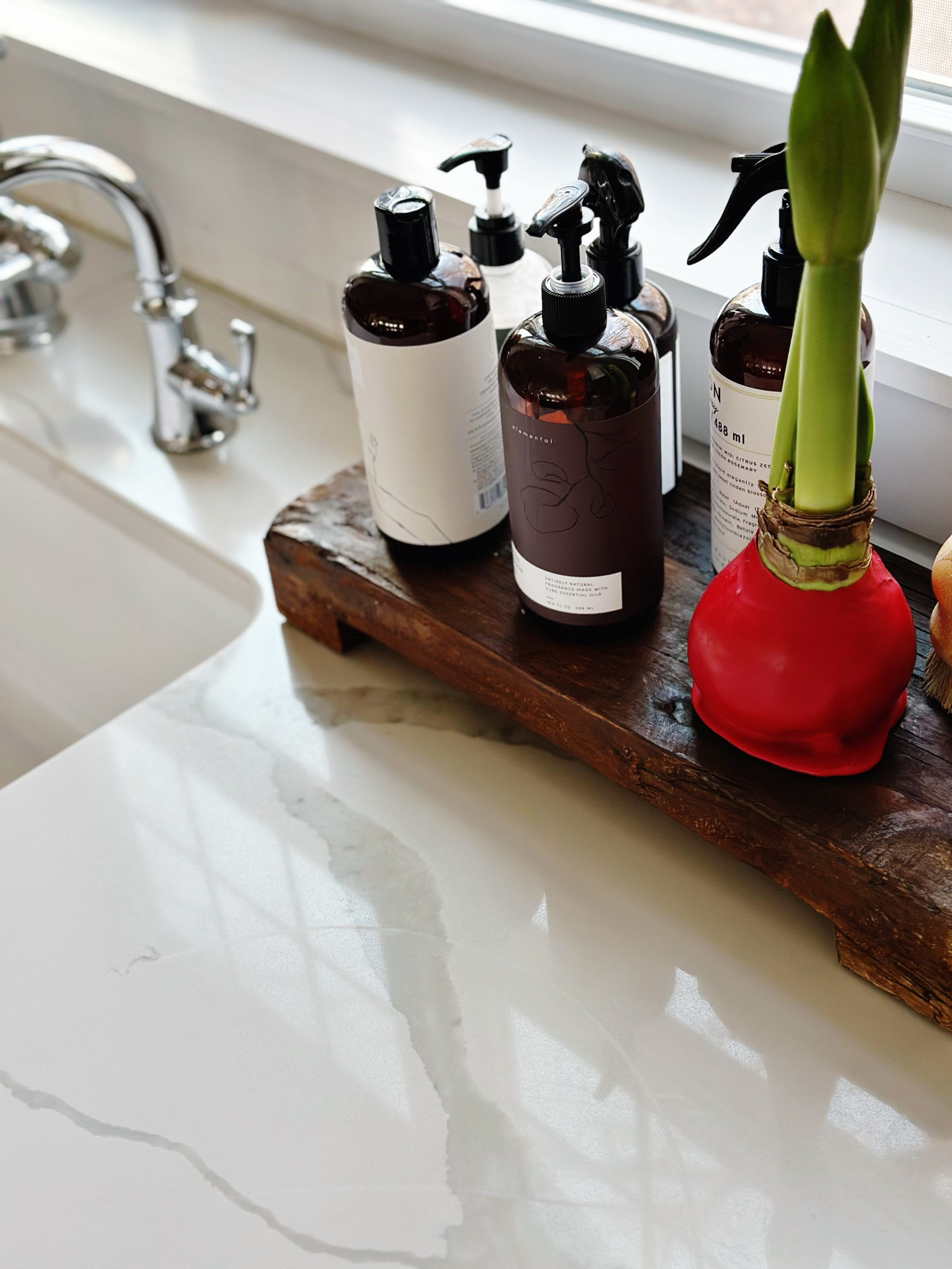 Tired of a cluttered kitchen sink area? Elevate your kitchen sink décor with a stylish reclaimed wood riser that combines beauty and functionality. This elegant solution corrals your dish soap, hand soap, counter spray, lotion, room spray, and dish brush, keeping them organized and within reach. The wood riser not only adds a designer touch to your kitchen décor but also maximizes counter space, making your daily routines more efficient.
The reclaimed wood riser is generously sized to accommodate all your kitchen essentials. Since the kitchen is the heart of the home, I prefer to invest in items that are both aesthetically pleasing, smell amazing, and are environmentally friendly (often vegan and cruelty free). I've tagged a few of my favorite natural, eco-friendly soaps that not only look beautiful but also smell divine. In addition to soaps, I like to include a live element on the tray to bring a touch of nature indoors. This season, I've chosen an amaryllis, but a candle would also make a lovely addition. All of my favorite items are tagged for you to check out. 

#LTKStyleTip #LTKFindsUnder50 #LTKHome