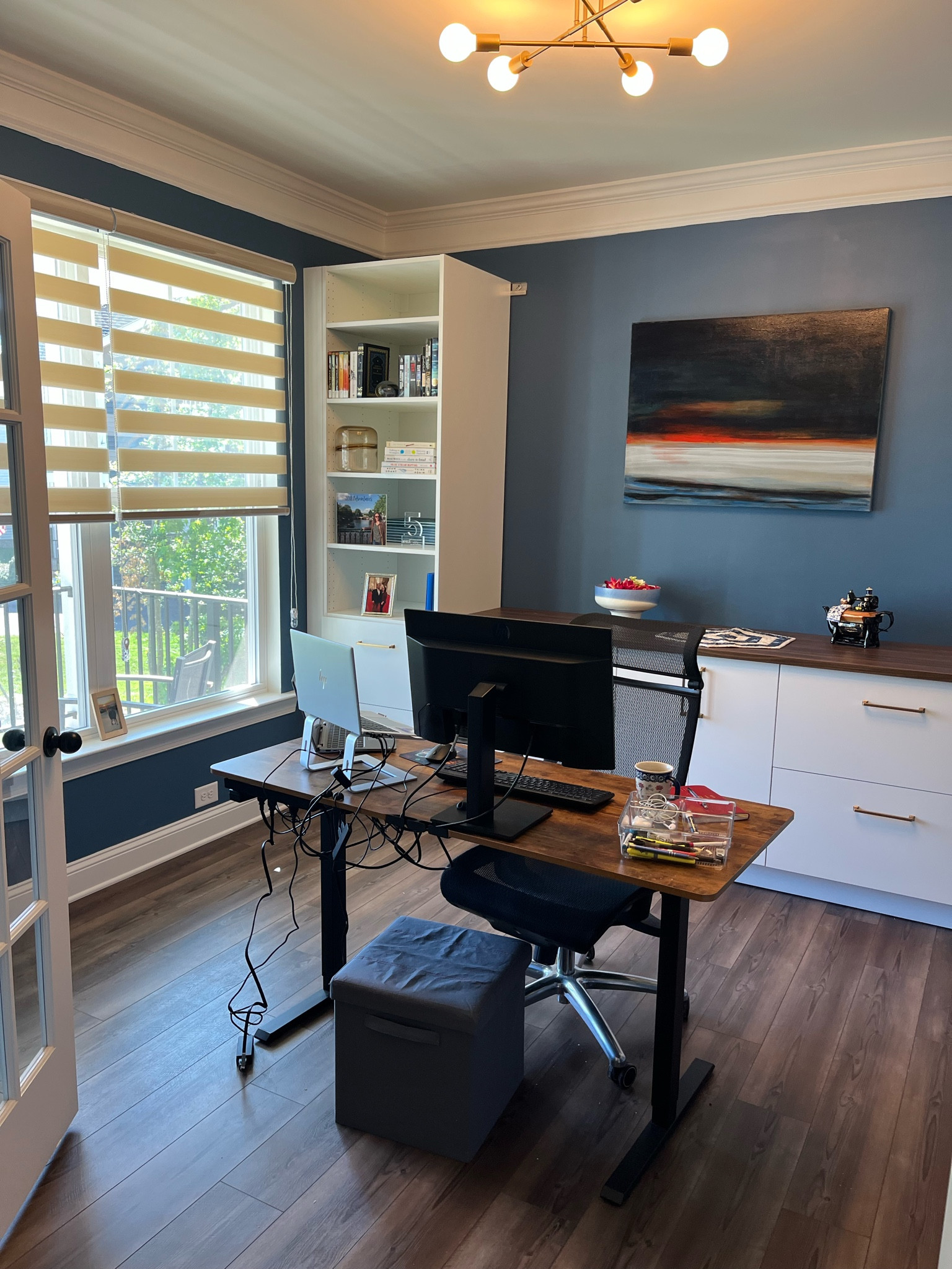 Redid my office with a row of Ikea built ins, SW inky blue paint, new light fixture, zebra shades, and art  