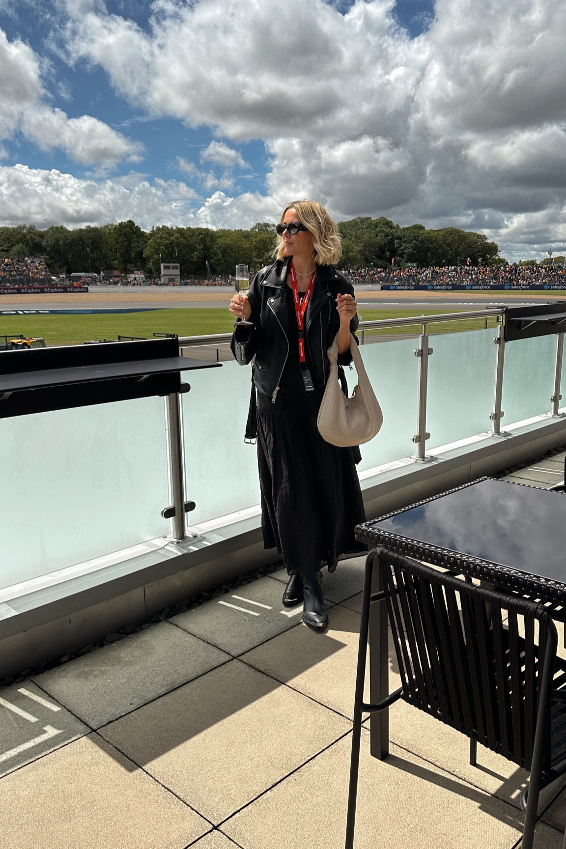 Formula 1 outfit, f1 outfit, black dropped waist dress, drop waist dress, oversized leather jacket, woven leather bag, western boots 