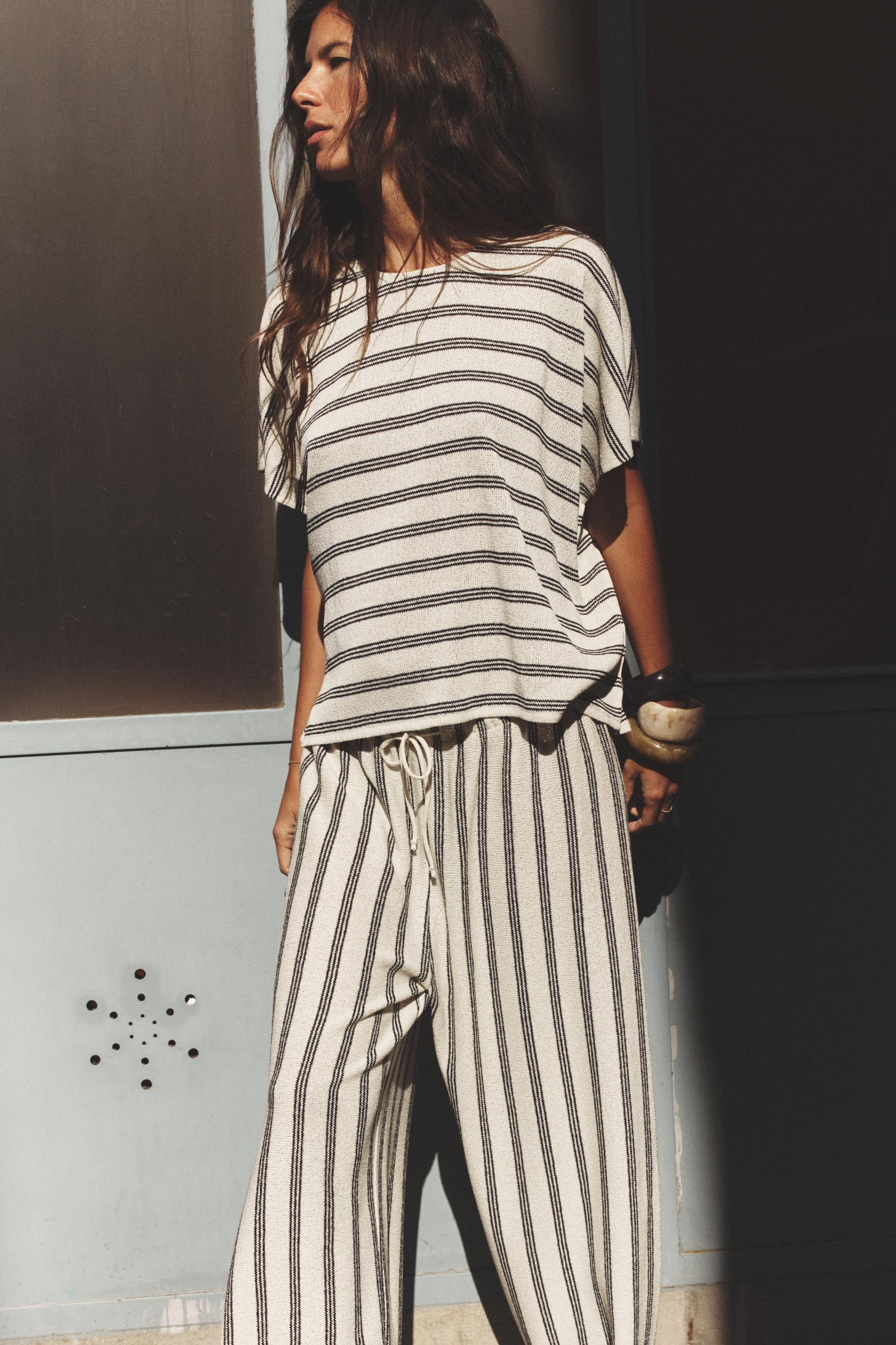 T-shirt made in flowing rustic-style fabric. Round neck and short sleeves.Black / White | 1058/16... | Zara US