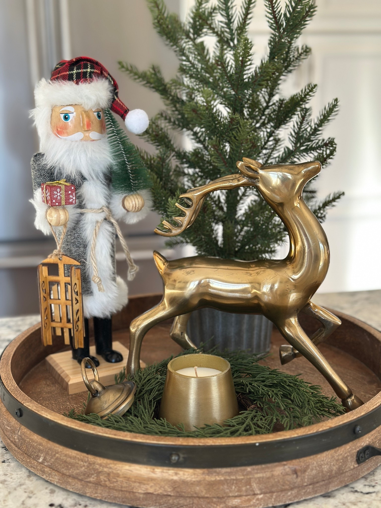 Classic Christmas vignette with round wood tray, Santa nutcracker, gold reindeer and gold bell candle.

#LTKHoliday #LTKHome #LTKSeasonal