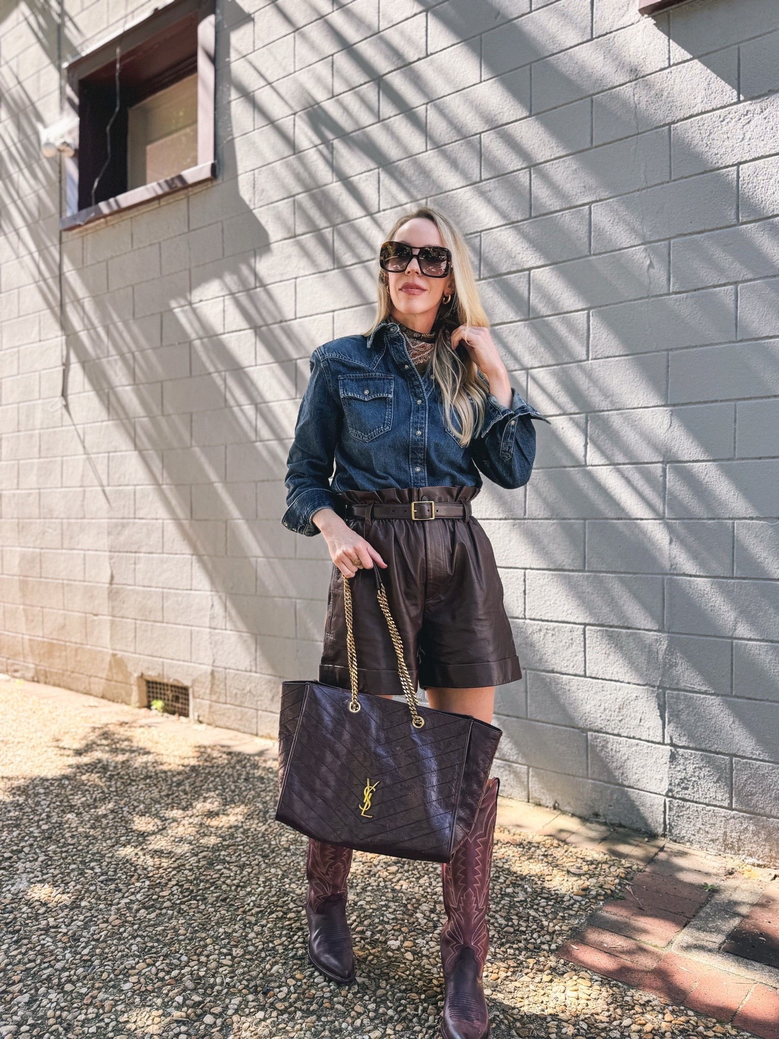 Western chic fall outfit with paisley silk scarf, @levi denim shirt, leather shorts, @Tecovas burgundy cowboy boots