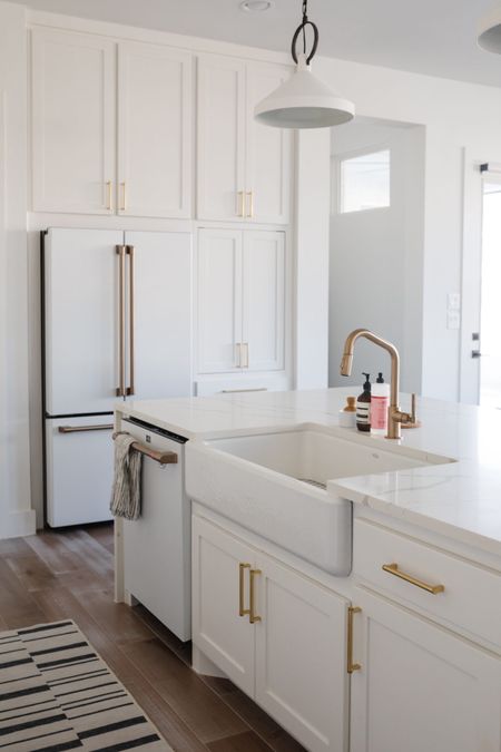 White kitchen details with an apron front sink, brass faucet, stripe kitchen runner that’s washable and white cafe appliances. Also linking our brass cabinet hardware. 

#LTKhome #LTKstyletip