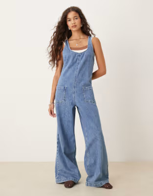 ASOS DESIGN - Denim tuinbroekjumpsuit met gekruiste achterkant en mid wash | ASOS (Global)